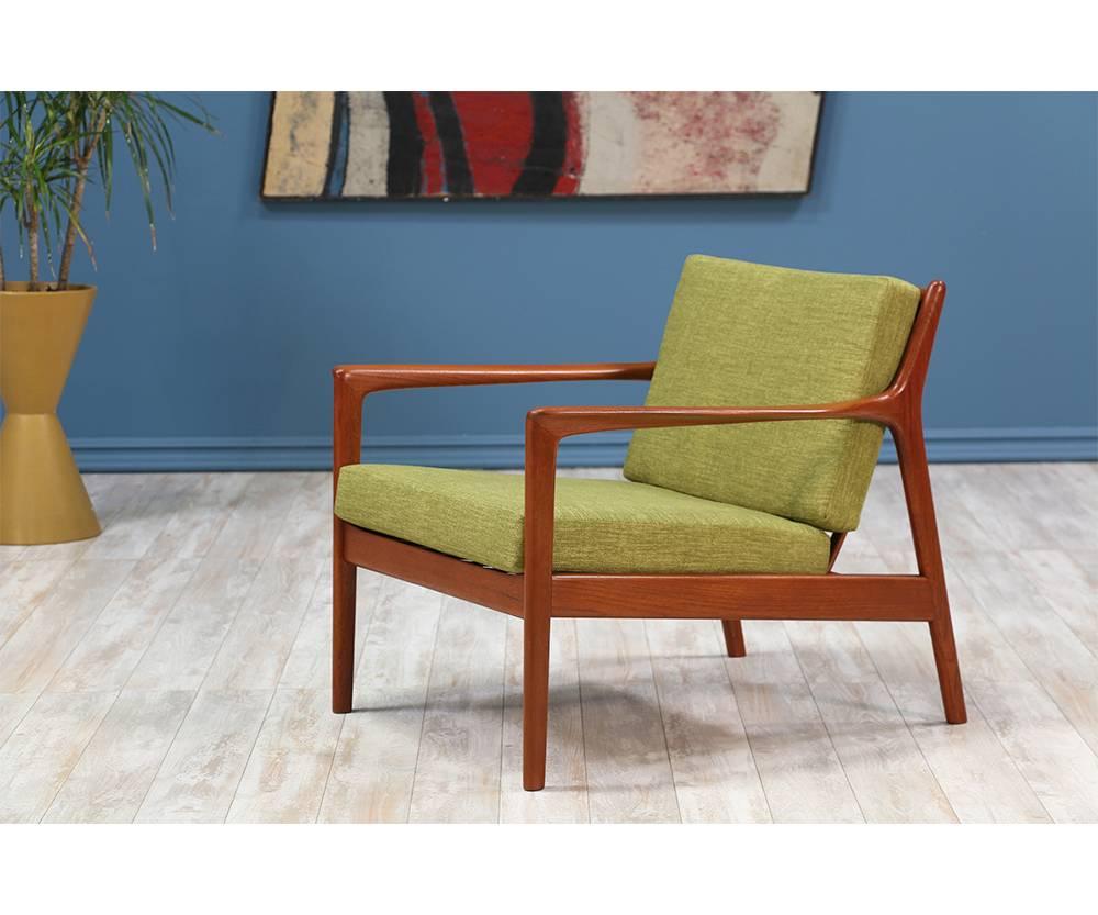 Model 74-C lounge chair designed by Folke Ohlsson for Dux of Sweden circa 1950’s. This chair features a solid walnut wood frame with eight slats on the open back. The wood was fully refinished by our expert craftsmen and includes new high-density