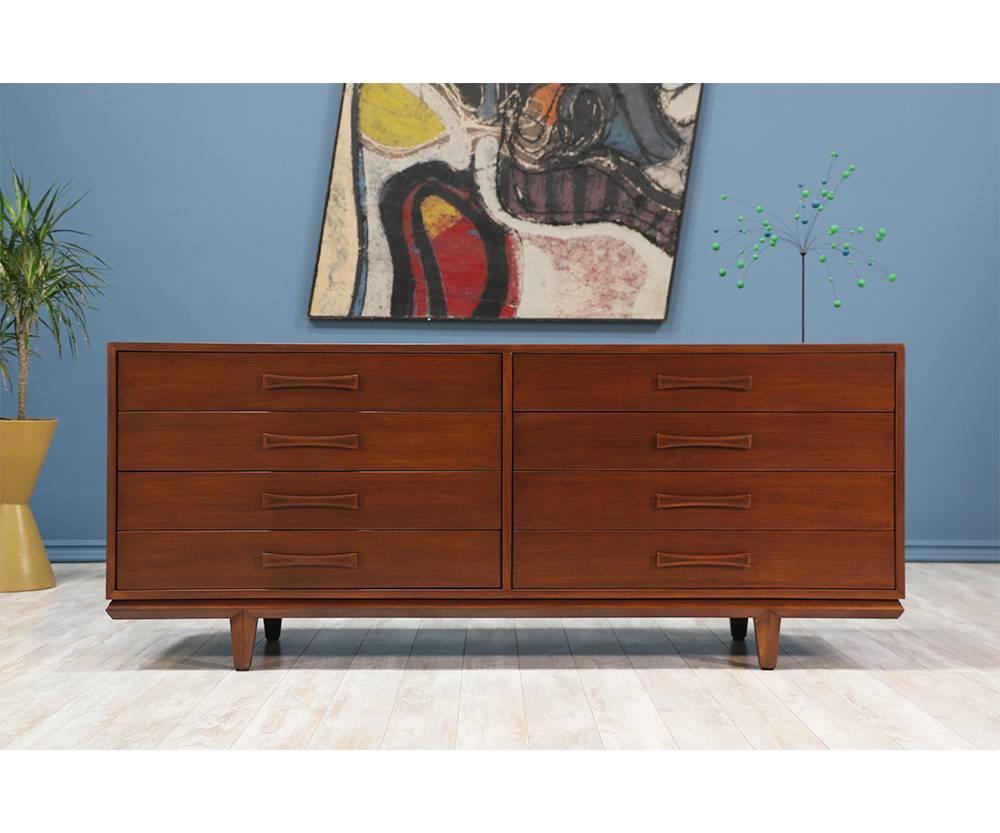 Mid Century Modern dresser manufactured by Cal Mode in the United States circa 1960’s. The simplistic design of this walnut wood dresser supports the idea of the modern aesthetic. The subtle details, including the bow tie drawer handles and defined