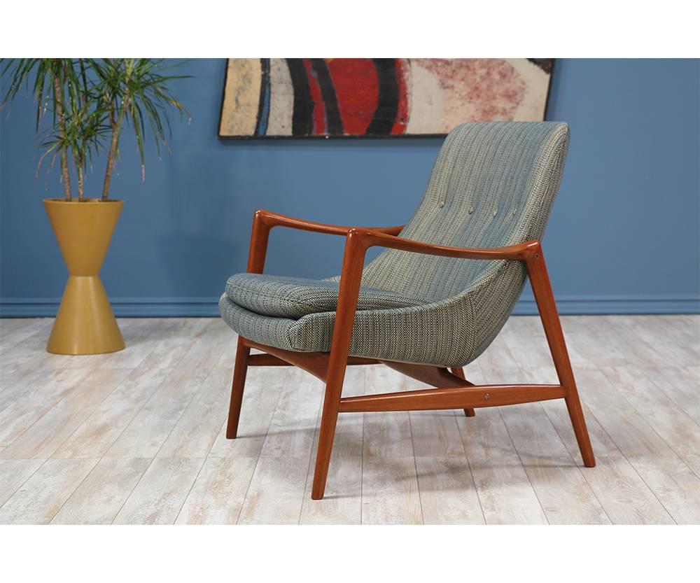 Lounge chair designed by master cabinet-maker, Adolf Relling for Dokka Møbler in Norway circa 1960’s. This high-quality lounge chair design is comprised of a solid teak wood frame with curvilinear arms that connect to the legs. Upholstered in a