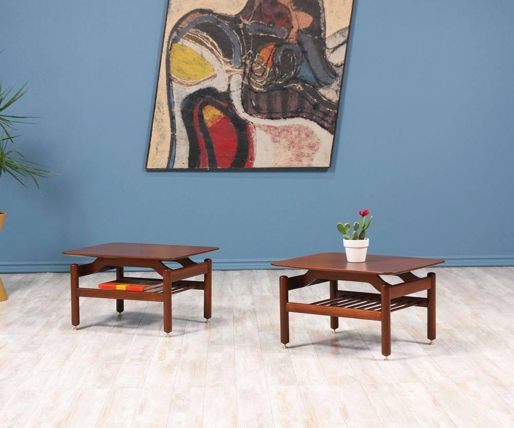 Pair of side tables designed by Swedish architect and furniture designer Greta M. Grossman for Glenn of California in the 1950’s. Made of quality materials, its walnut wood structure and brass hardware create a compelling and graceful mix of lines