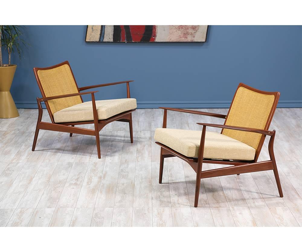 Pair of lounge chairs designed by Ib-Kofod Larsen and manufactured by Selig in Denmark circa 1960’s. This iconic pair features tapered arm rests that resemble spears hence the given name. The back legs delicately curve out and connect to the arms.