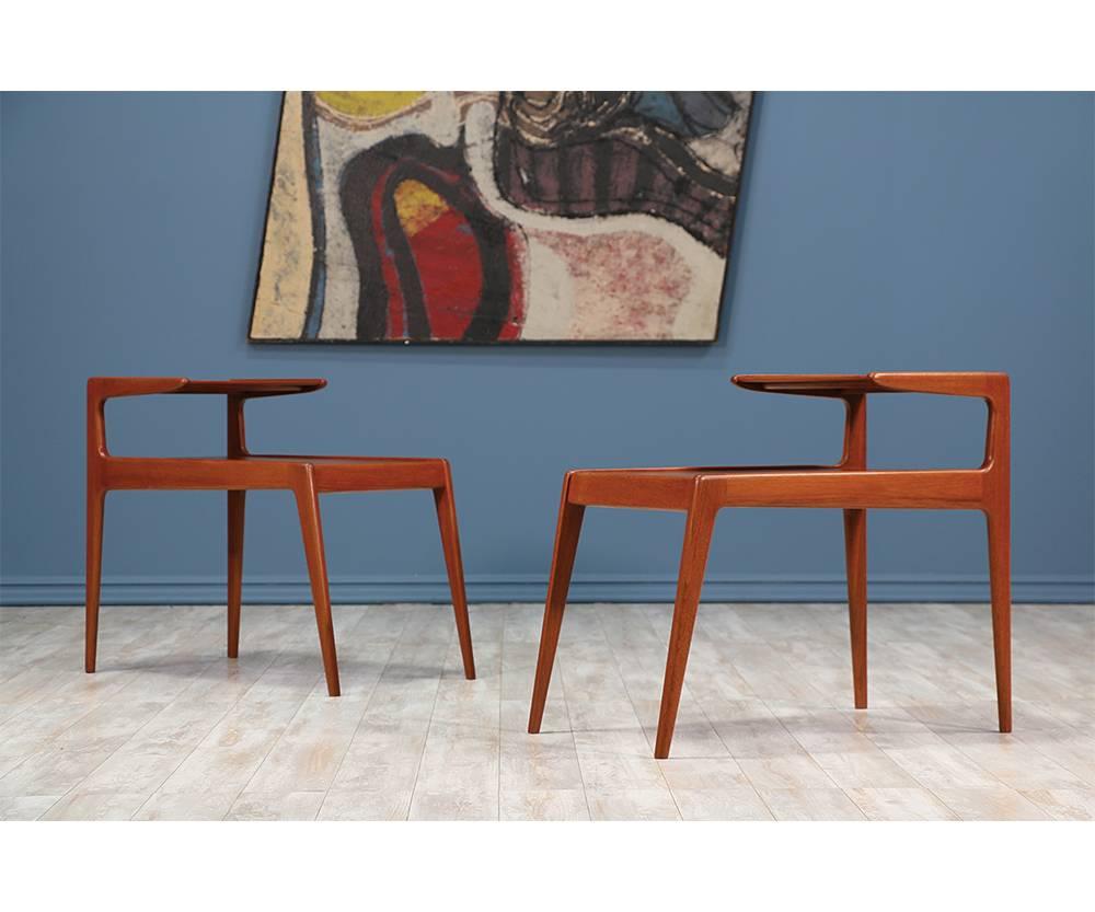 Pair of Danish Modern side tables designed by Kurt Østervig and manufactured by Jason Møbler in Denmark circa 1960’s. This set of tables with two tiers and sharp, clean lines are a great example of well-crafted minimalistic design. Their versatility