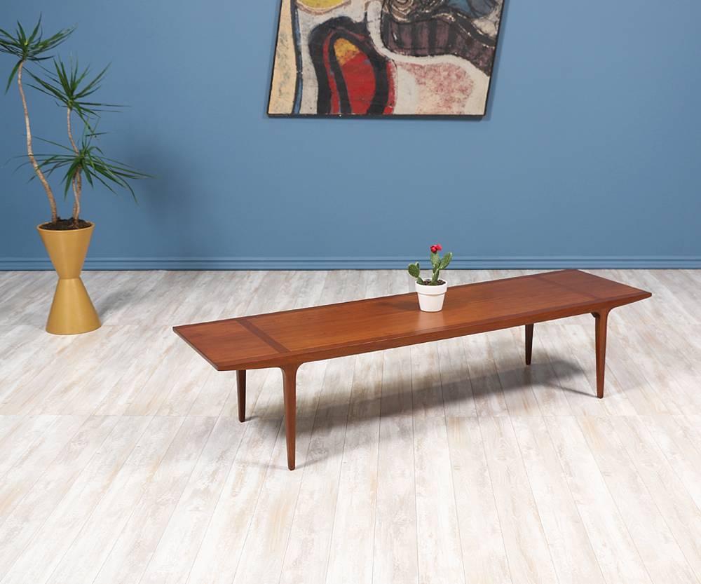 Mid-Century Modern coffee table designed by American designer John Van Koert and manufactured by Drexel in the United States in the 1950’s.  Made of walnut wood, this coffee table’s gentle curves, clean lines, and four smooth tapered legs make this