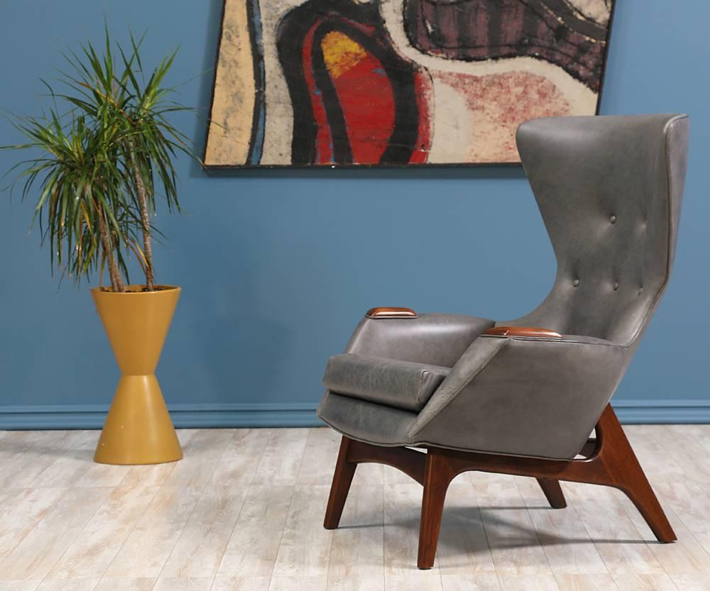 Mid Century Modern high back chair designed by Adrian Pearsall for Craft Associates in the United States c. 1960’s. Featuring a solid walnut sculptural base, wood padded arms, and a molded plywood back rest, this chair has been upholstered in a