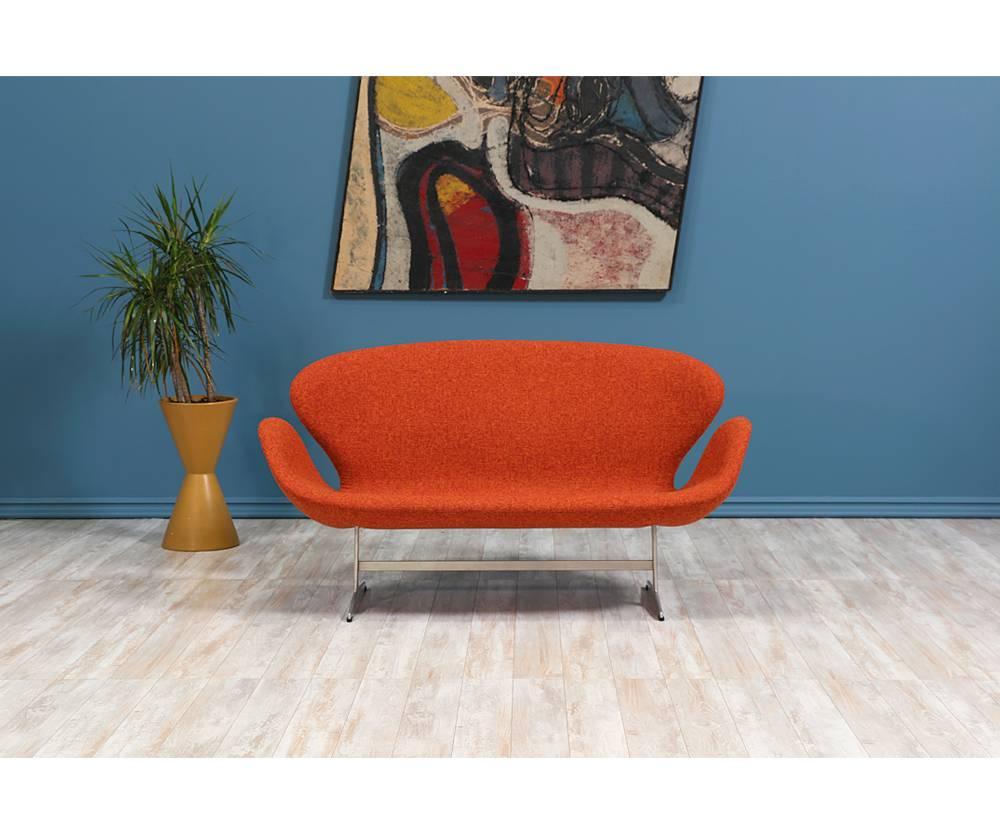 Originally designed for the SAS Royal Hotel in Copenhagen, the Swan sofa by Danish design pioneer, Arne Jacobsen, has become iconic and synonymous with Danish Modern. Reupholstered in a gorgeous orange tweed fabric, this comfortable design retains
