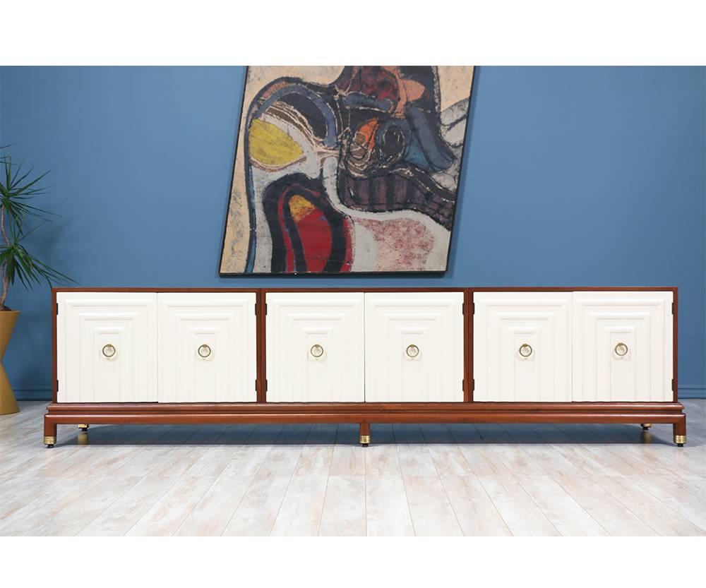 Two-Toned Lacquered and Walnut credenza designed by American designer Renzo Rutili for Johnson Furniture Company in the 1950’s. This beautiful credenza features three compartments with adjustable shelves in each. The rich walnut tone on the casing