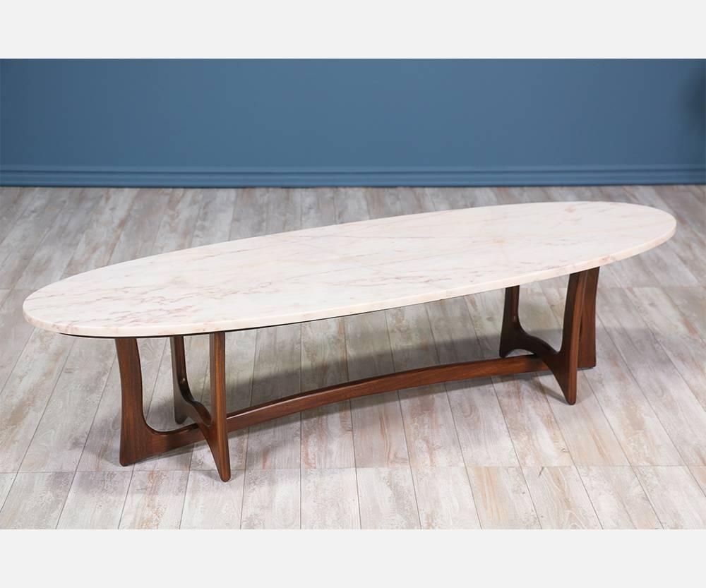 Mid-Century Modern sculpted coffee table designed and manufactured in the United States circa 1960. This elegant coffee table maintains its original top showing minor wear on the marble. The sculptural base shows clean, modern lines comprised of