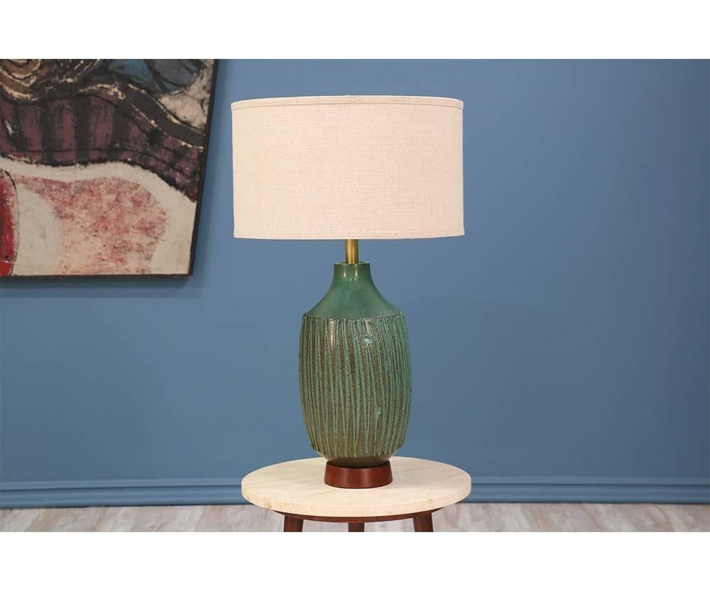 Ceramic table lamp designed by pottery maker, David Cressey, for Architectural Pottery in California circa 1970’s. Crafted with textured ceramic representative of Cressey’s designs and adorned with a walnut base that accentuates the teal color. This