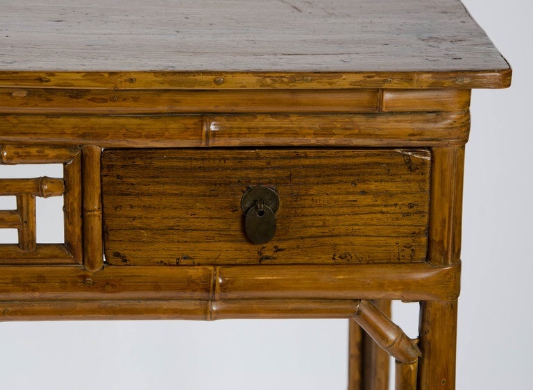 An unusual early 19th century Chinese table. Of bamboo and soft wood and pegged construction it is finished all round as a centre table and has two frieze drawers.