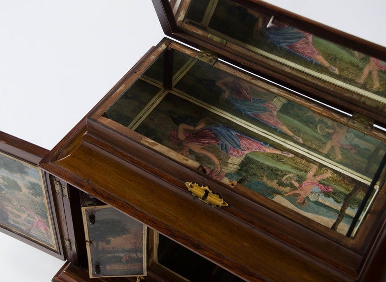 A wonderful 19th century table cabinet incorporating earlier oil painting panels.
The decorated interior with drawers and central atrium in which to display a prized possession to show ones “Cabinet” friends.