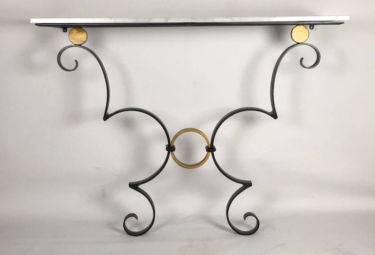 A beautiful handmade iron strap work console table with white Carrara marble top; the scroll base hand-forged and finished in black and gold.
Designed and made for Bly Contemporary at John Bly.