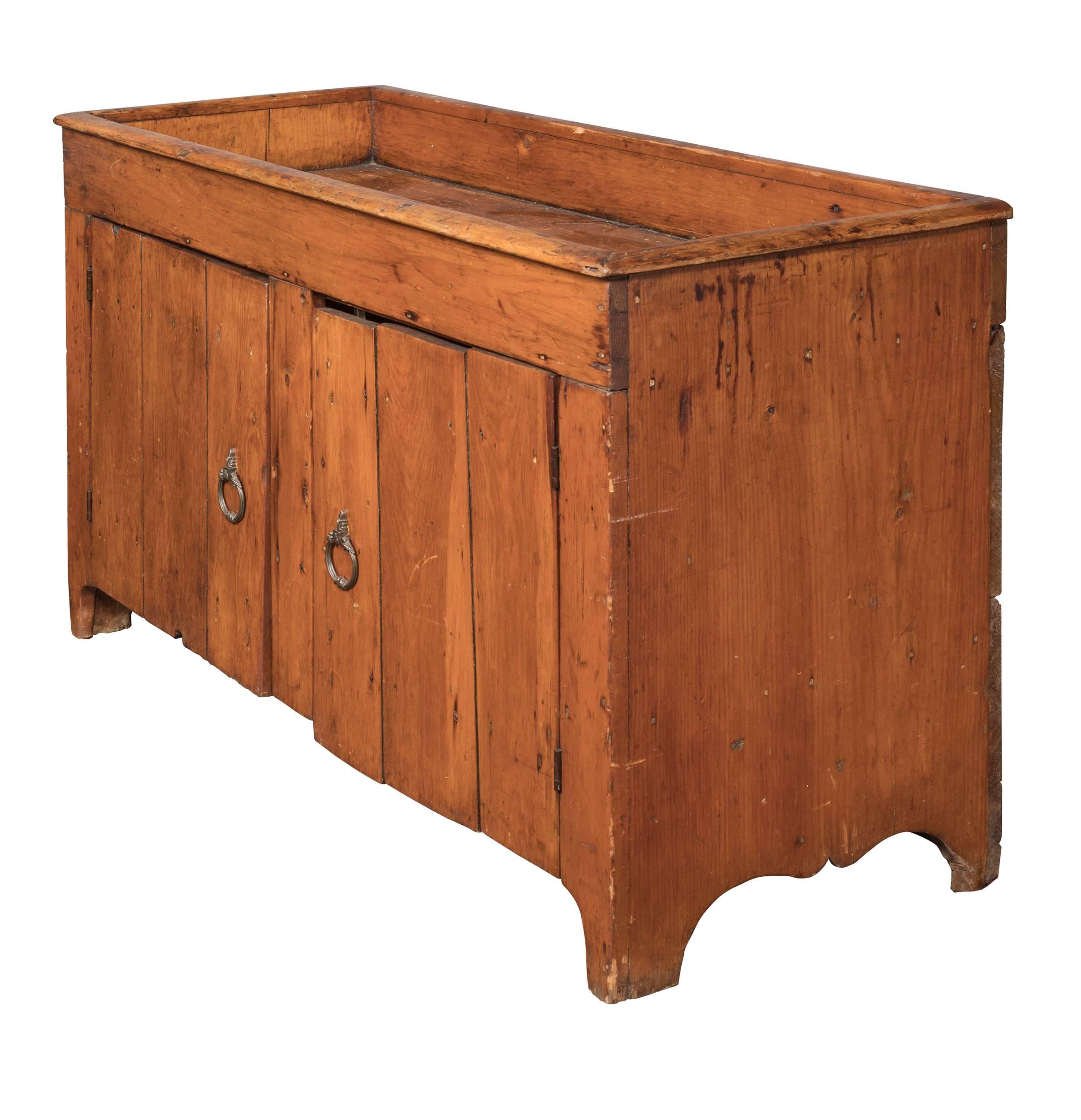 Very charming 19th century American dry sink. Pinewood is wonderfully patinated with age. Large sink area, cabinet space below with pair of grooved slat doors. It is in very sturdy condition.