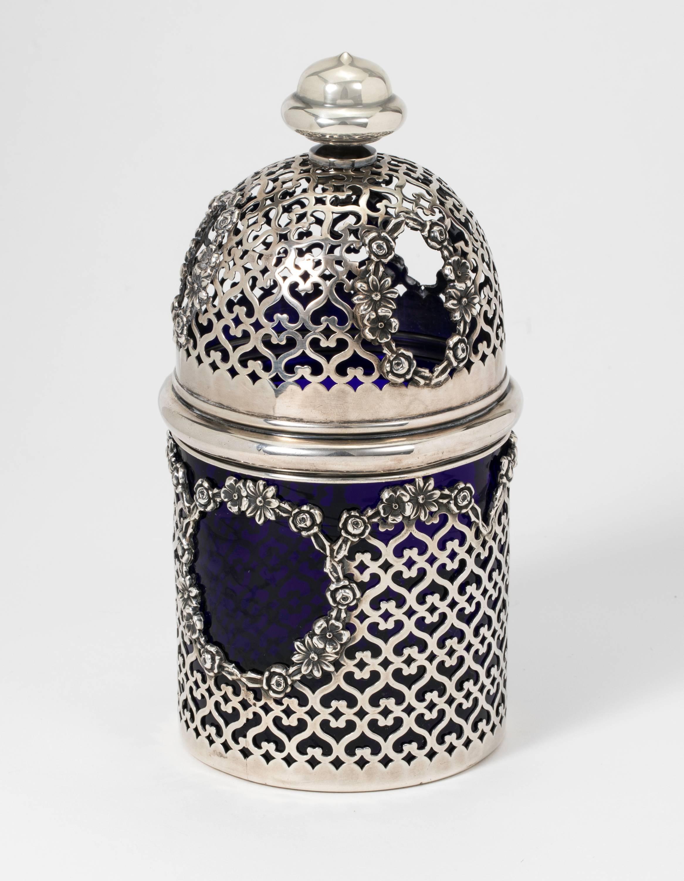 Rare, Potpourri Jar.   Pierced floral design sterling silver basket housing a blue cobalt glass jar, from circa 1940s.
Beautiful matching domed lid is also sterling pierced for functional aroma therapy. There is an interior hook for holding a wet