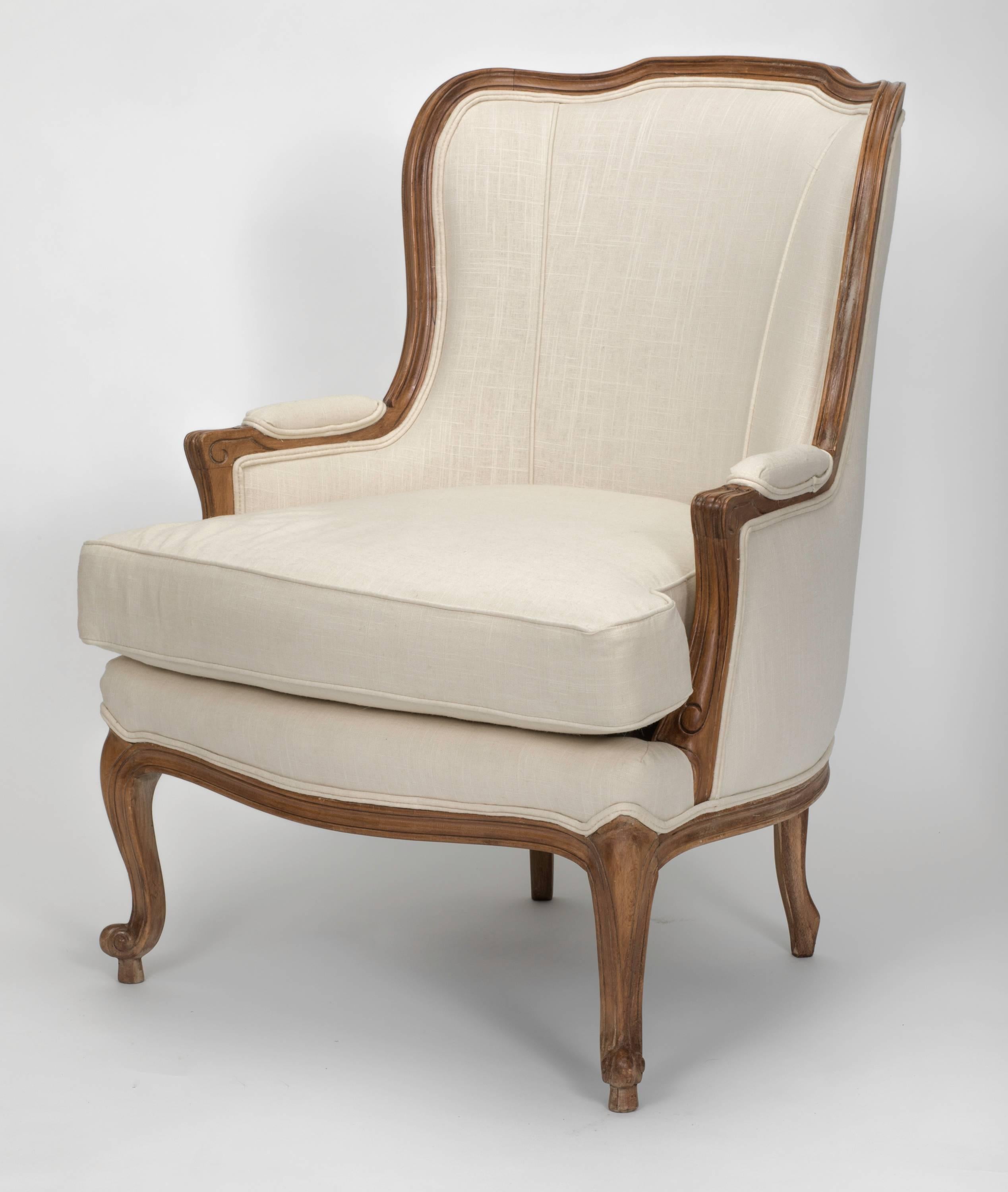 Louis XV style beechwood frame wingback chair. Newly upholstered in creamy white linen. Beautiful clean lines, very comfortable chair.