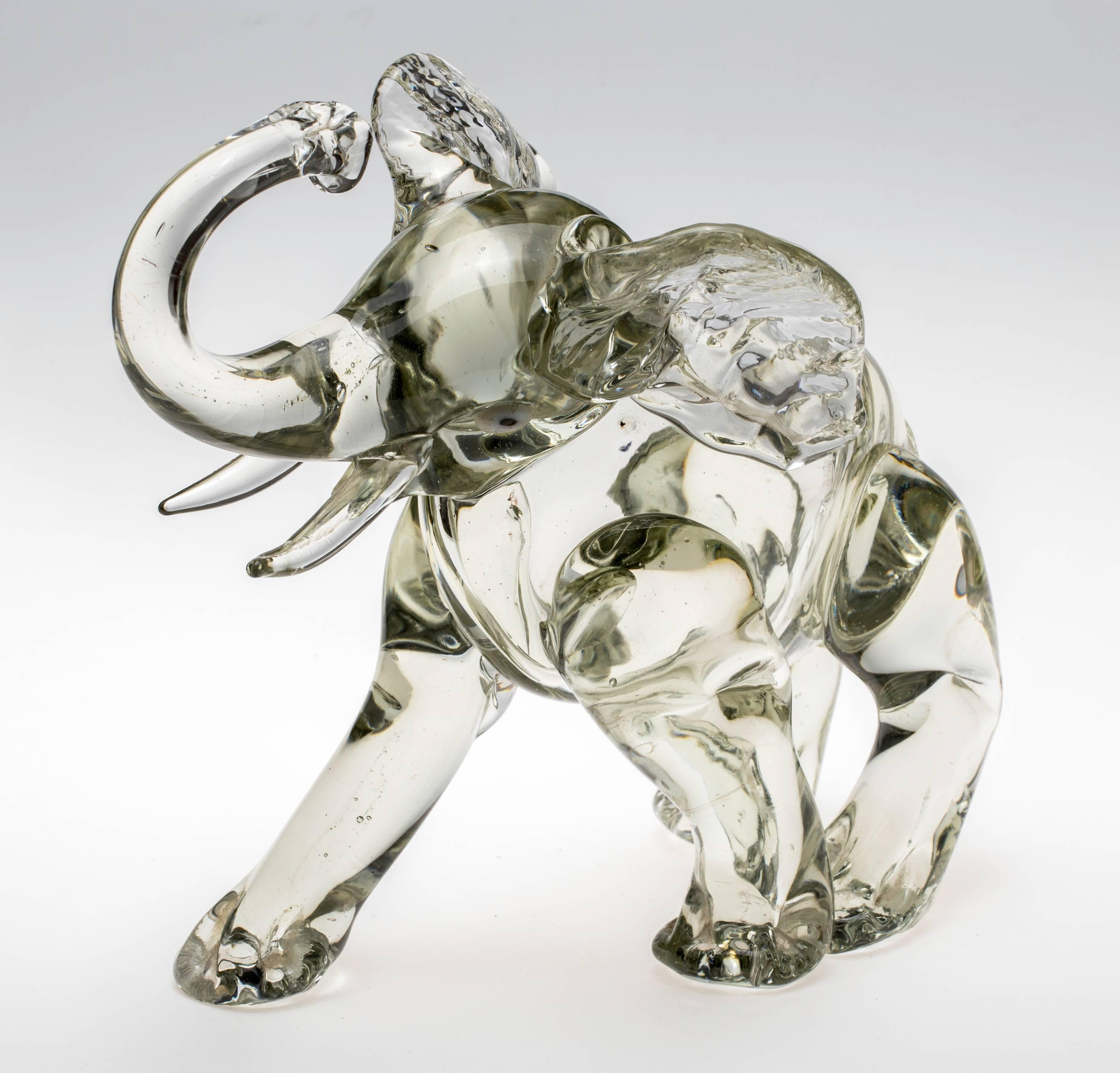 Beautifully made in Italy, Murano glass elephant sitting down on hind legs with its trunk up in the air. Chunky light grey color. Nice to touch.