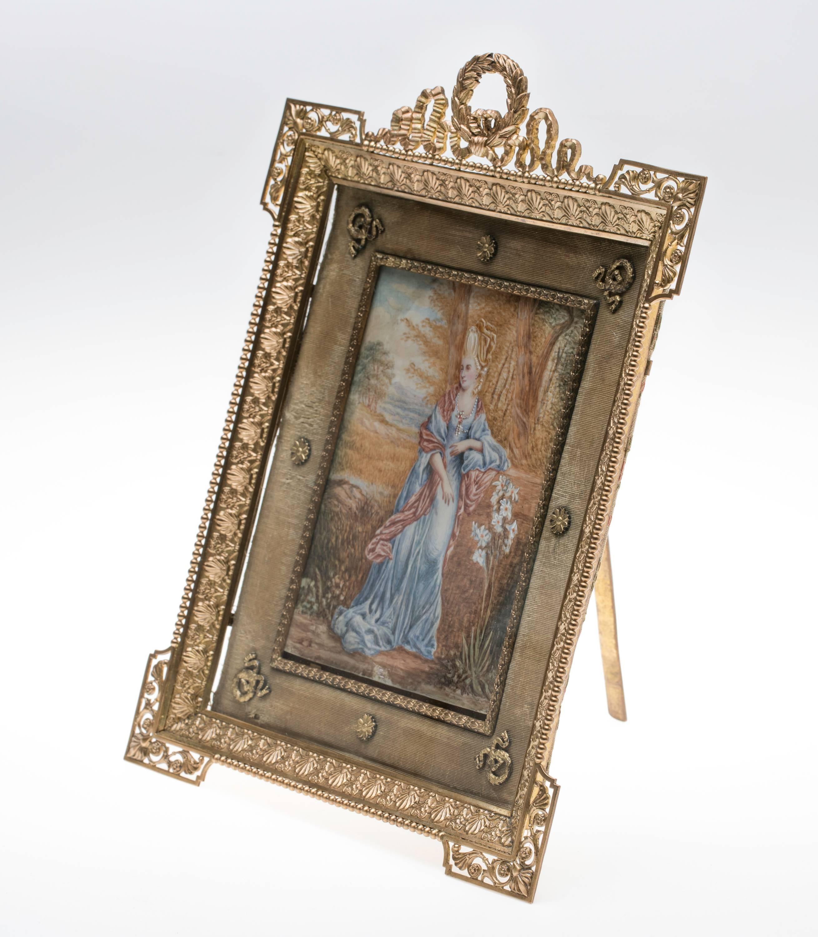 Lovely 1930s gilt bronze picture frame. Decoratively made with wreath and ribbons. Velvet inset frame.