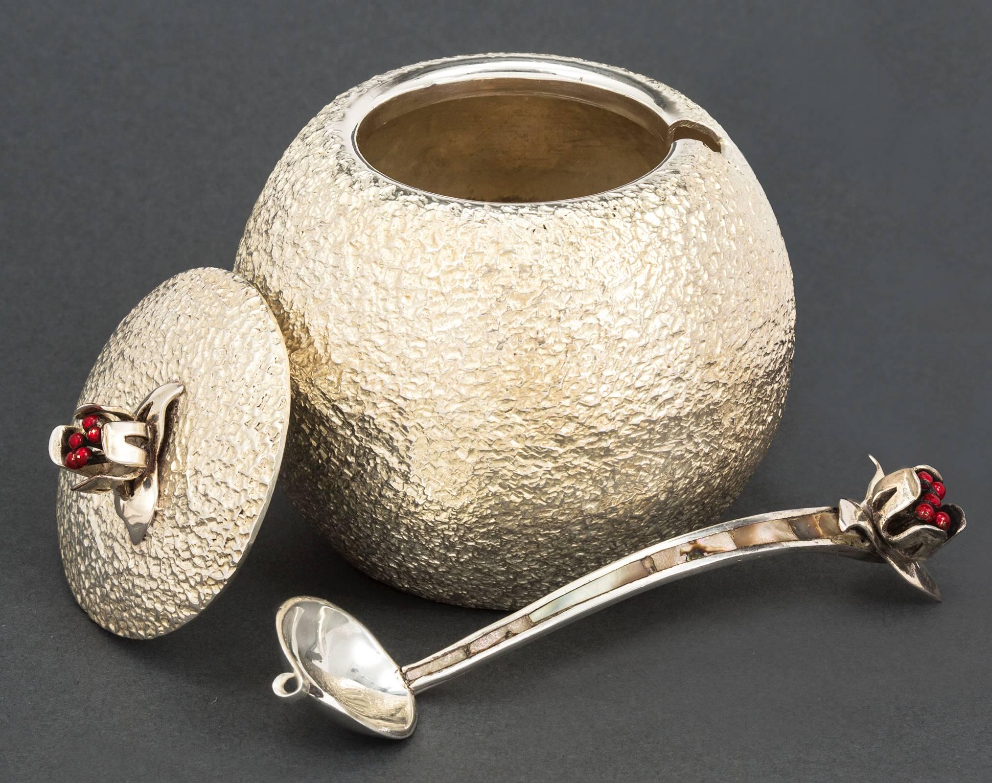 Charming round sugar lidded bowl with spoon. All hammered textured silver plated. Lid and the spoon is accented with decorative red enamel berries.
Signed underneath the bowl.
Excellent condition.