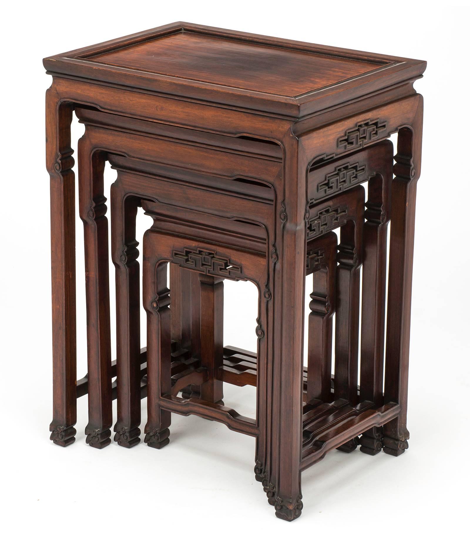 Handsome set of four nesting tables. It is made of rosewood, beautifully aged over the years with carved aprons. Simple and beautifully made. A very practical and useful set. Nesting table sizes: 14 D x 20 W x 27 H, 12 D x 17 W x 23.75 H, 9.75 D x