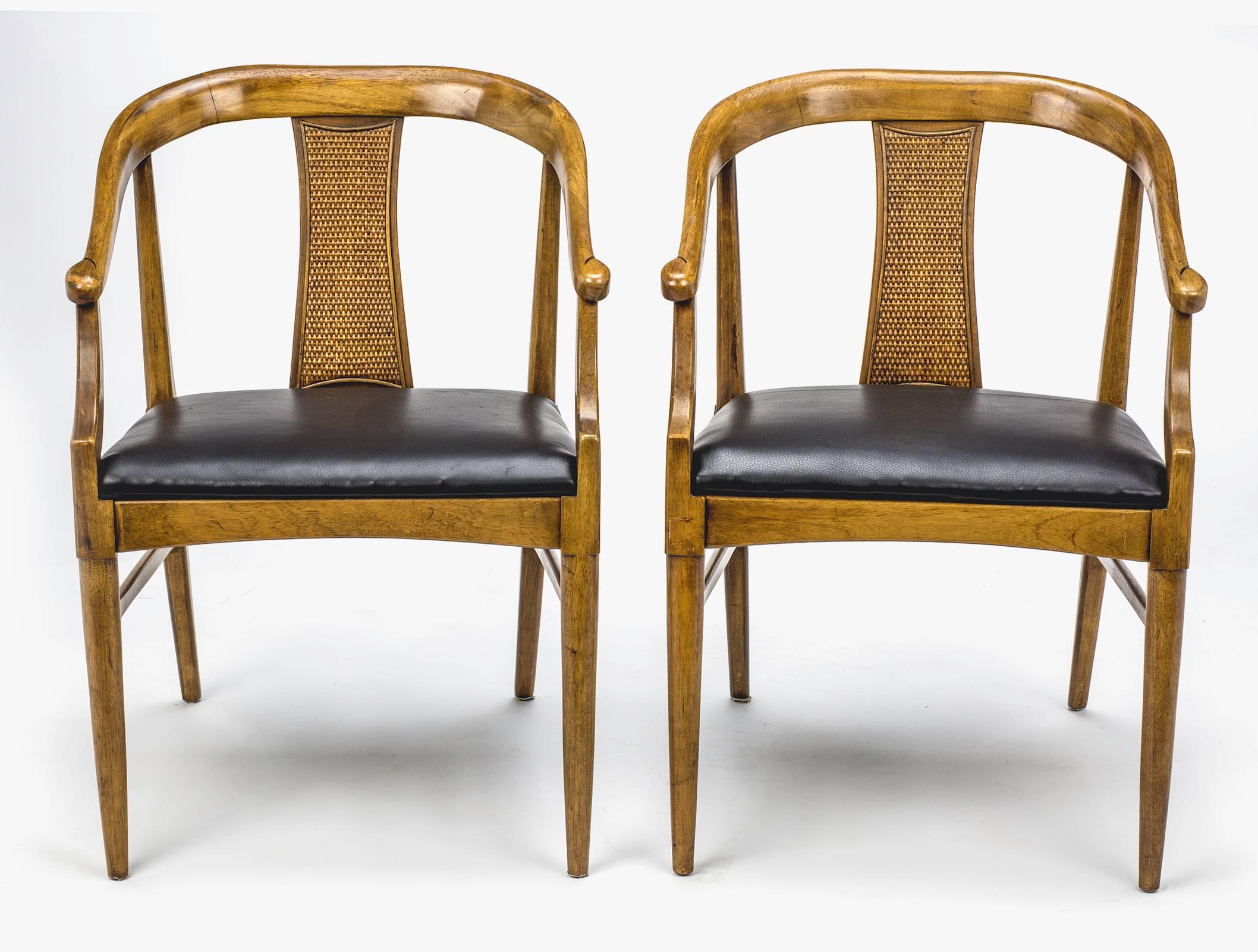 1960s, walnut wood, beautiful Danish yoke style armchairs. Sleek simple lines,  back accent in bamboo caning with wood backing.  Newly upholstered  black leather seats. Comfortable and sturdy. Minor blemish on leather.
  