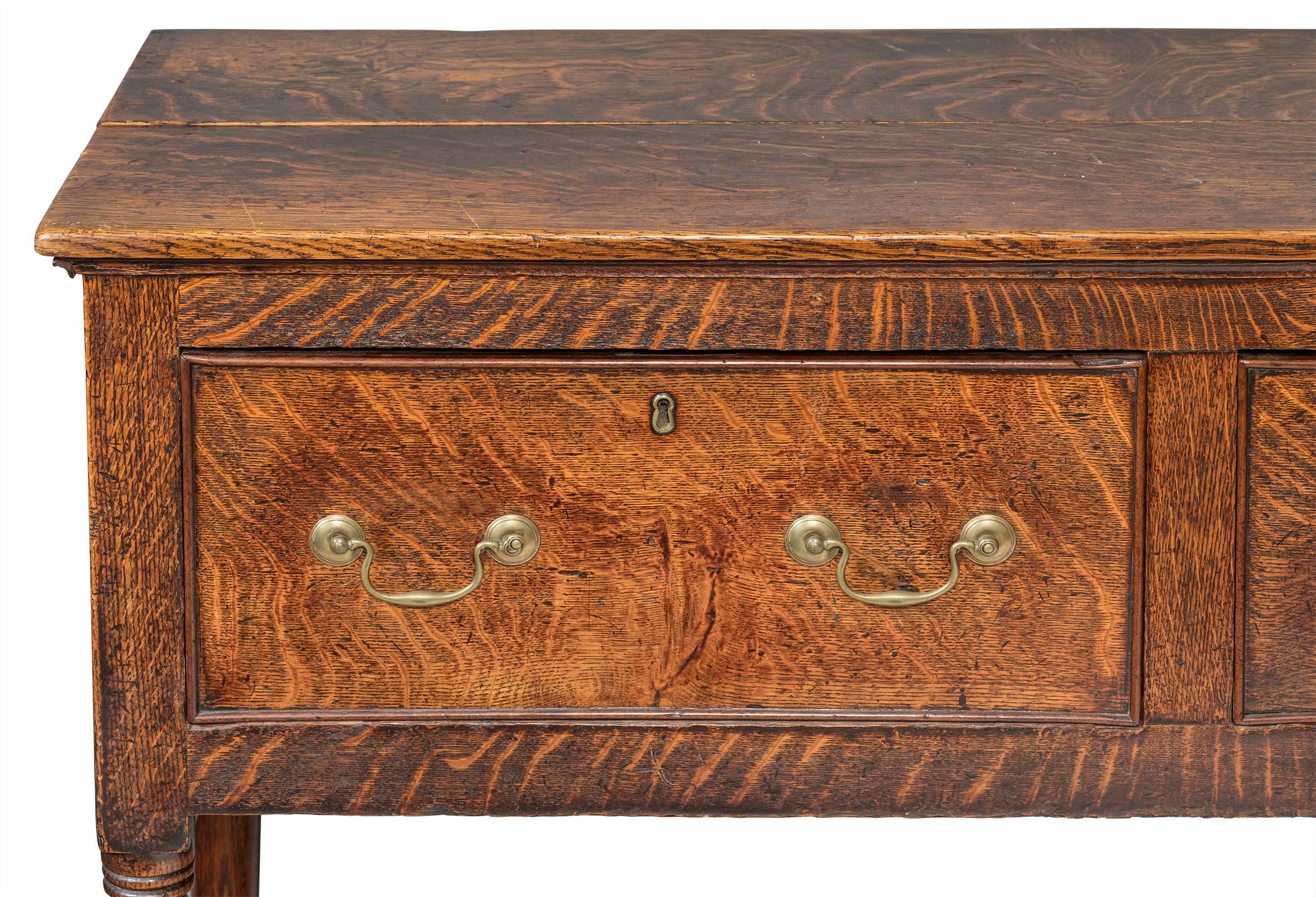 19th century English oak server. Very handsome piece, wonderful original patinated finish. Three-drawer buffet with double brass handles. Middle drawer is lined with silver tarnish felt. Simple turned legs. Excellent sturdy condition.