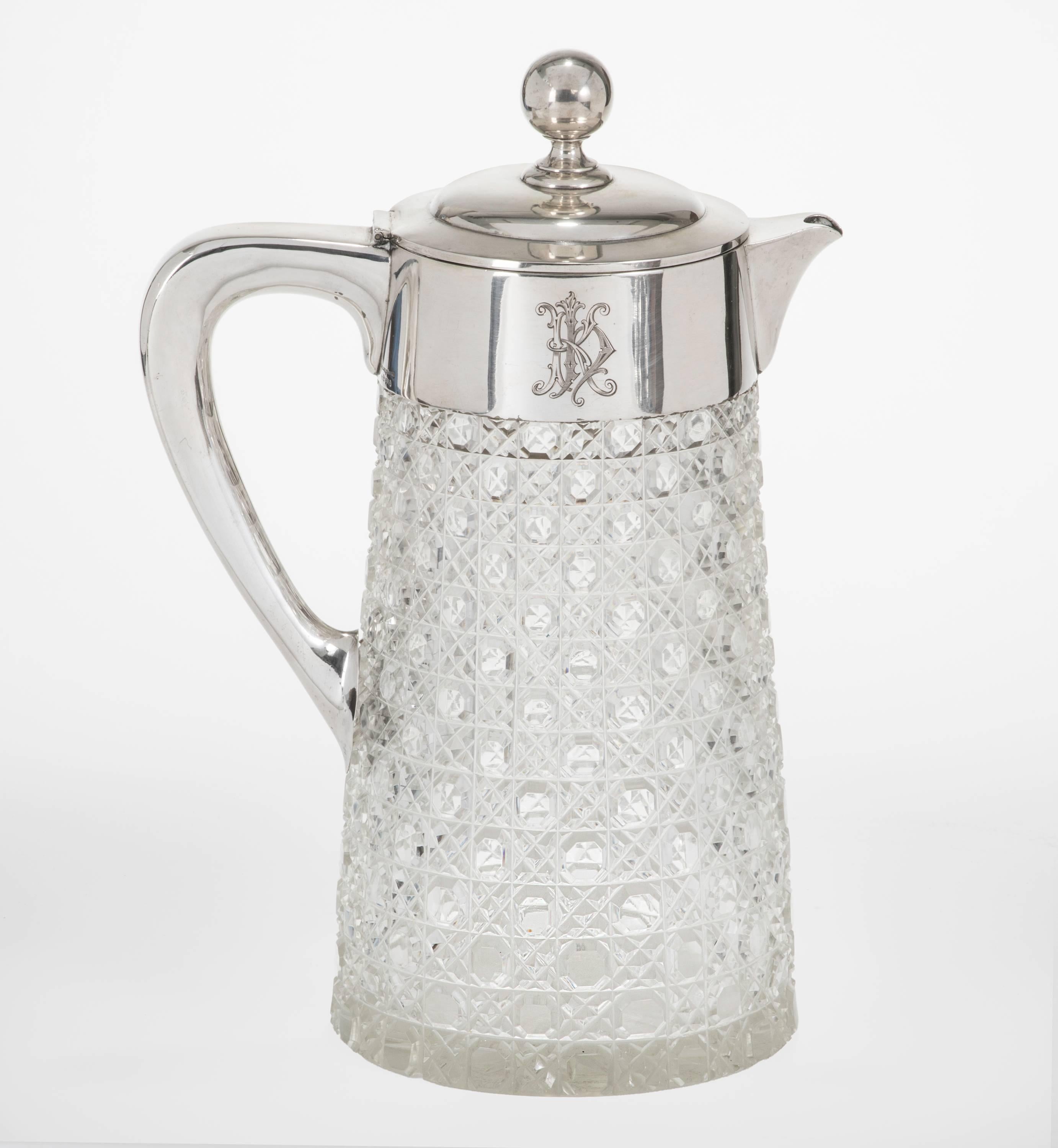 Beautiful cut crystal base pitcher or decanter with 800 Sterling German silver spout hinged lid and handle. One side  is engrave with very handsome German crest. And the other side a lovely scrolled monogram .  Hallmarked at the back of the neck