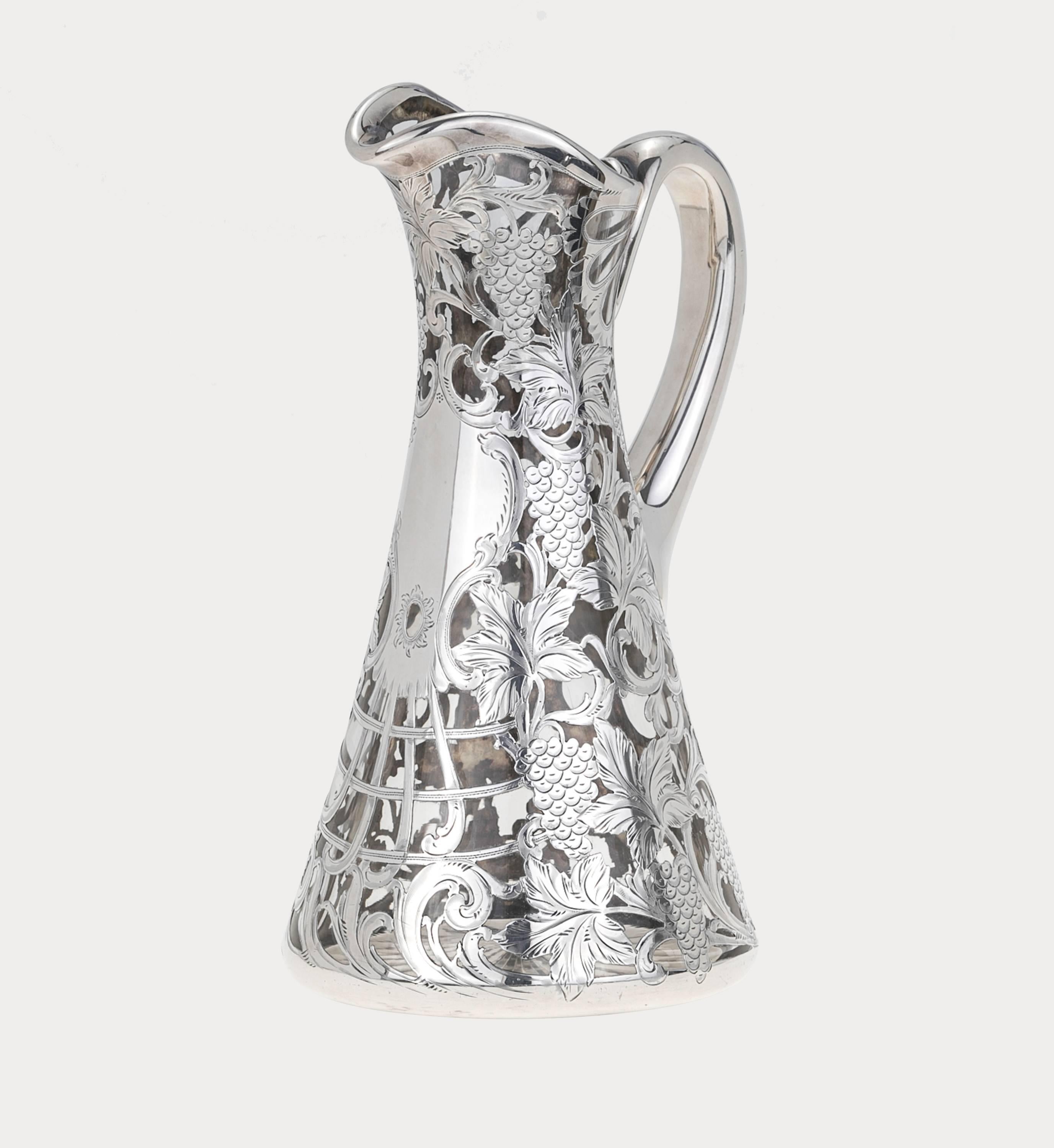 Beautifully etched heavy thick sterling silver overlay in vine grape design on crystal glass pitcher, circa 1900s. Highly decorative, perfect as claret jug. Hallmarked below the handle. Alvin Manufacturing co. 
Patent 3802 999/1000.