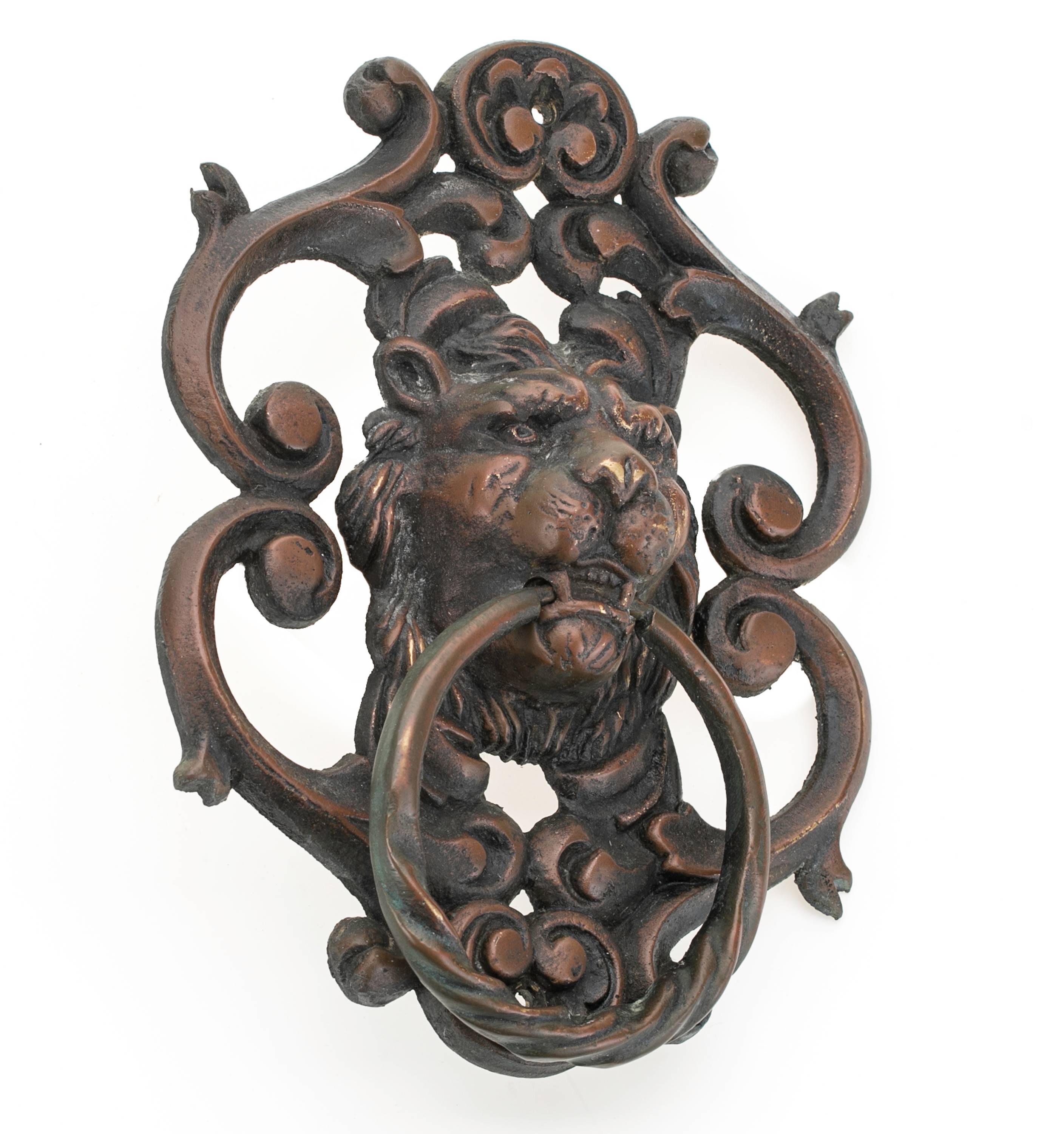 Cast bronze lion face door knocker, circa 1920s. Fierce looking lion head embellished in scrolled works, patinated bronze in copper finish.
A very handsome stately piece.
