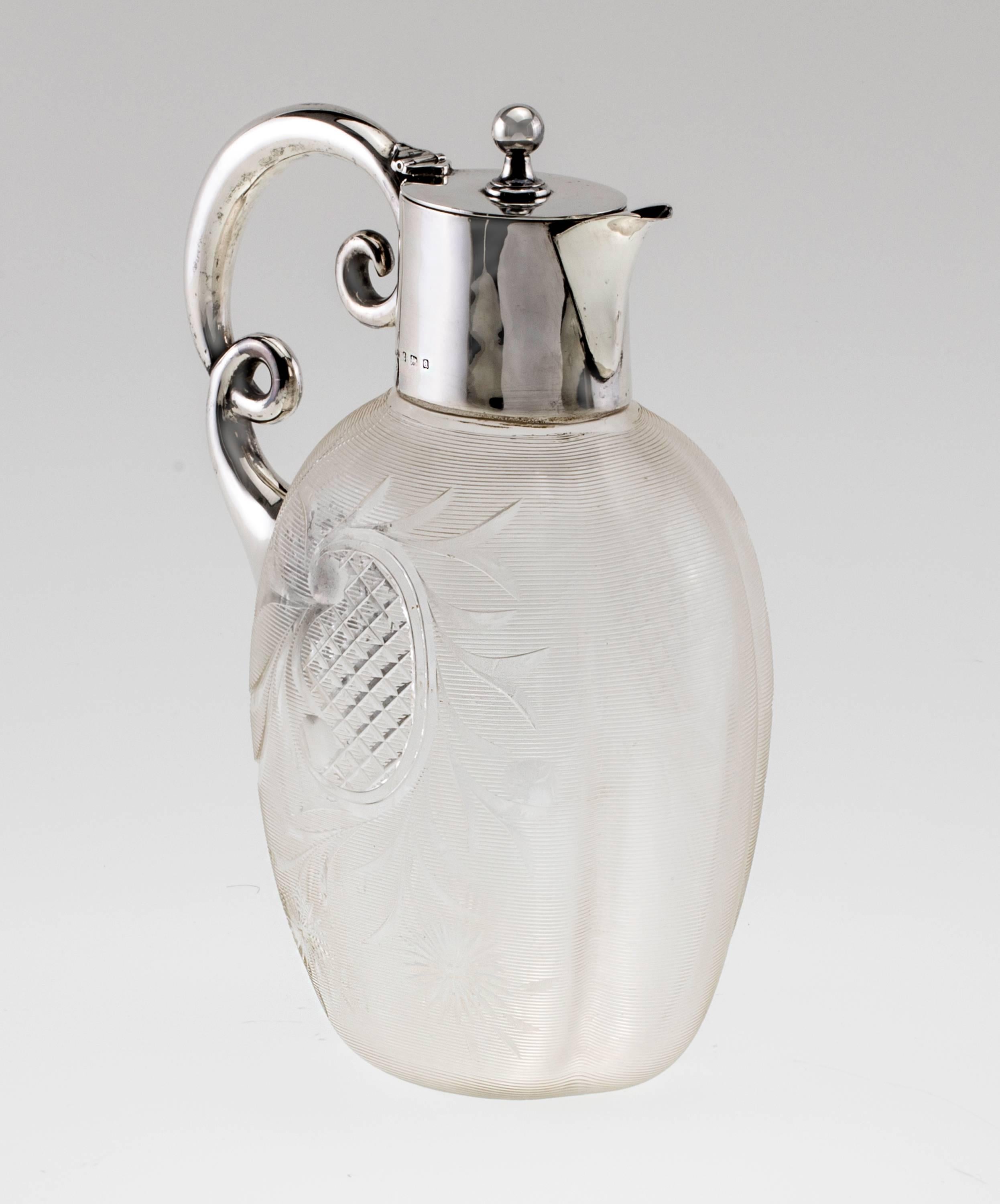 Fine, elegant Sterling silver mount Claret Jug. Base is Crystal glass textured in fine etched lines and cut floral design. English Hallmarked on the silver neck. Lovely double curly handle design.