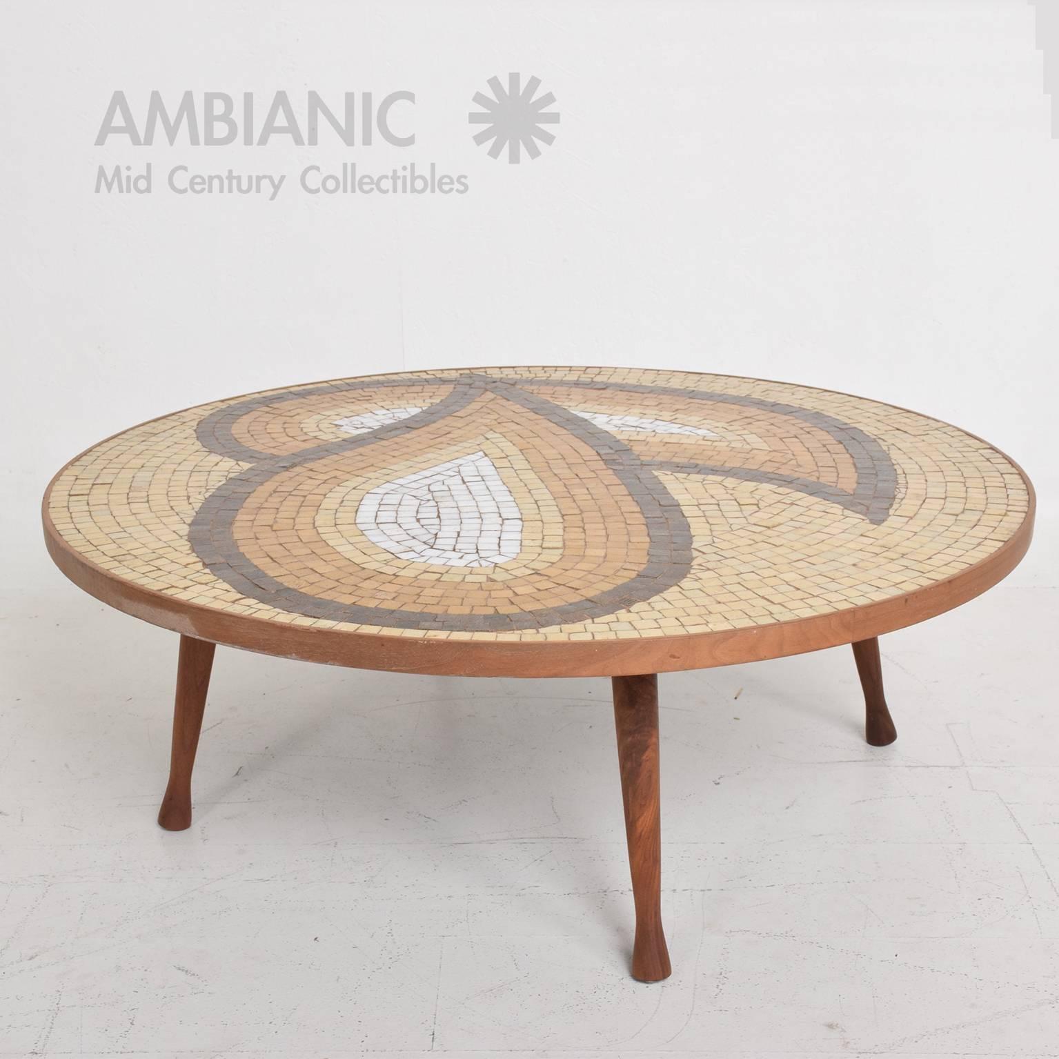 For your consideration a vintage Mid-Century Modern coffee table with round shape. Sculptural tile pattern in tan and brown tones with walnut legs and walnut band.

Legs can be removed for safe and easy shipping.

No stamp present from the