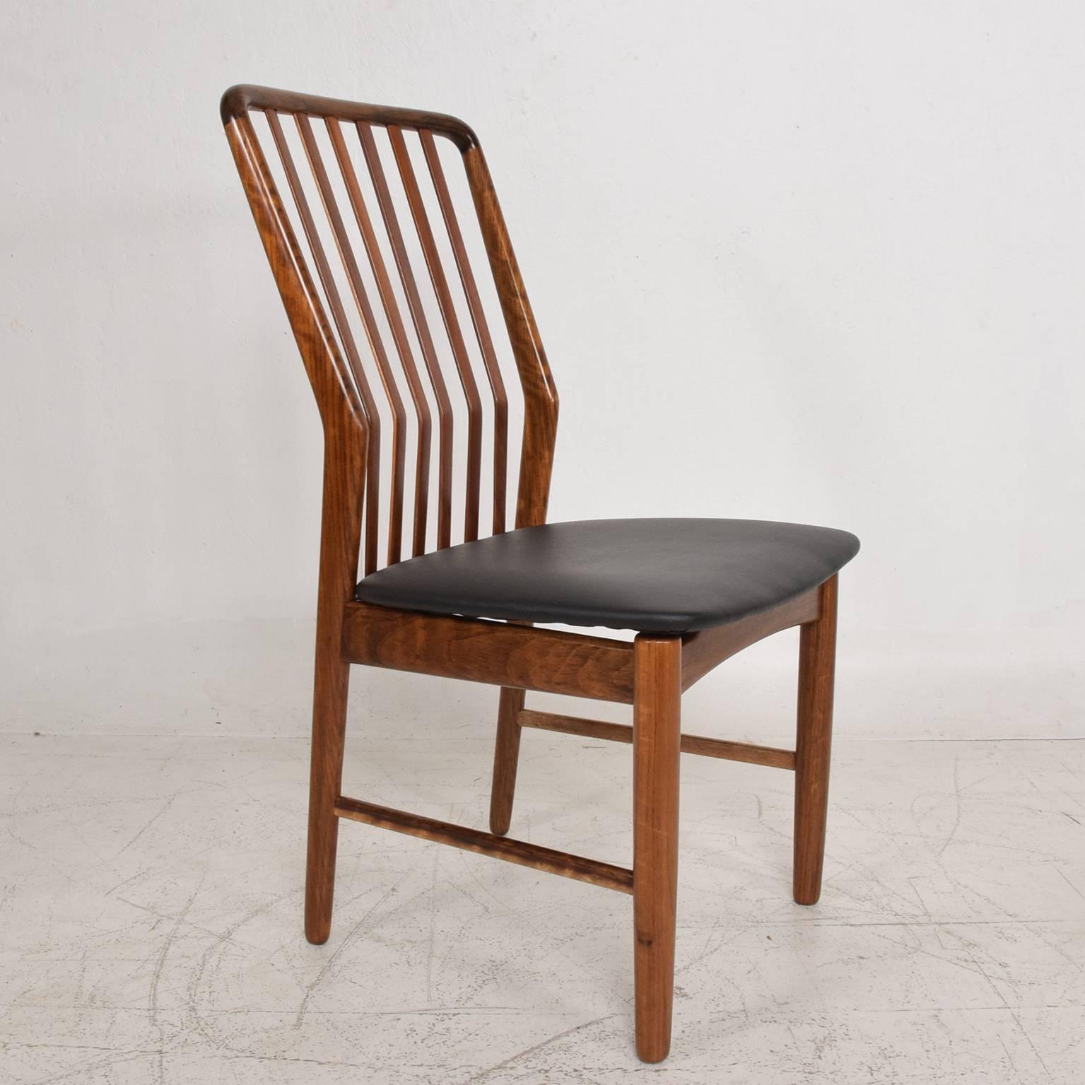 A set of six (6) dining chairs by Moreddi. 
Made in Denmark, circa 1960s. 
Beautiful unique wood grain. Black faux leather upholstery.
Dimensions: 36" H x 22" D x 19 1/4" W, seat 17" H.