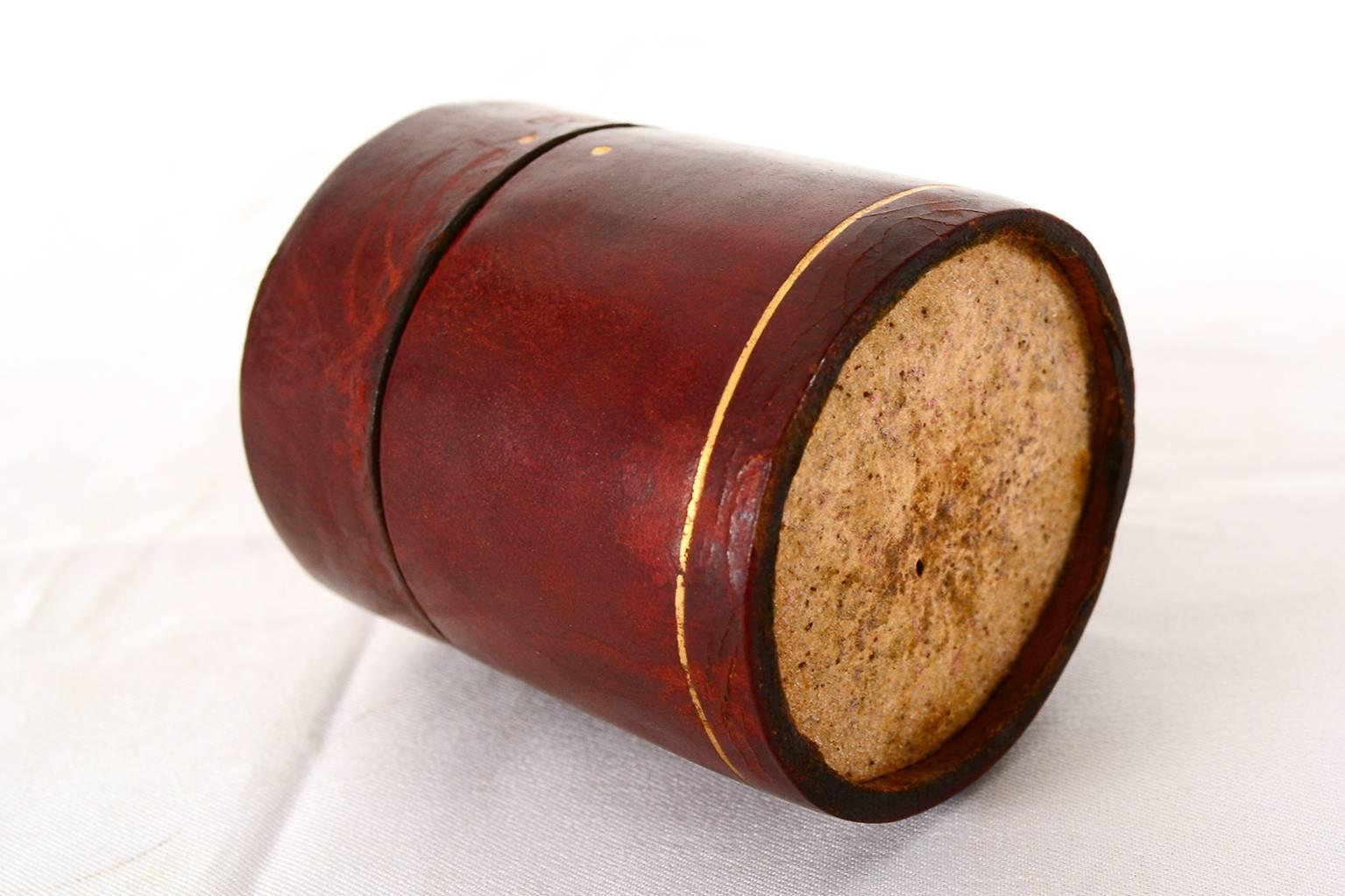 Unusual matches box in a circular shape. Unusual burgundy red leather with gold accent paint.

The lid closes very tight. Inside the compartment you can store the matches. 

Unmarked
after Dupré-Lafon (HERMES).