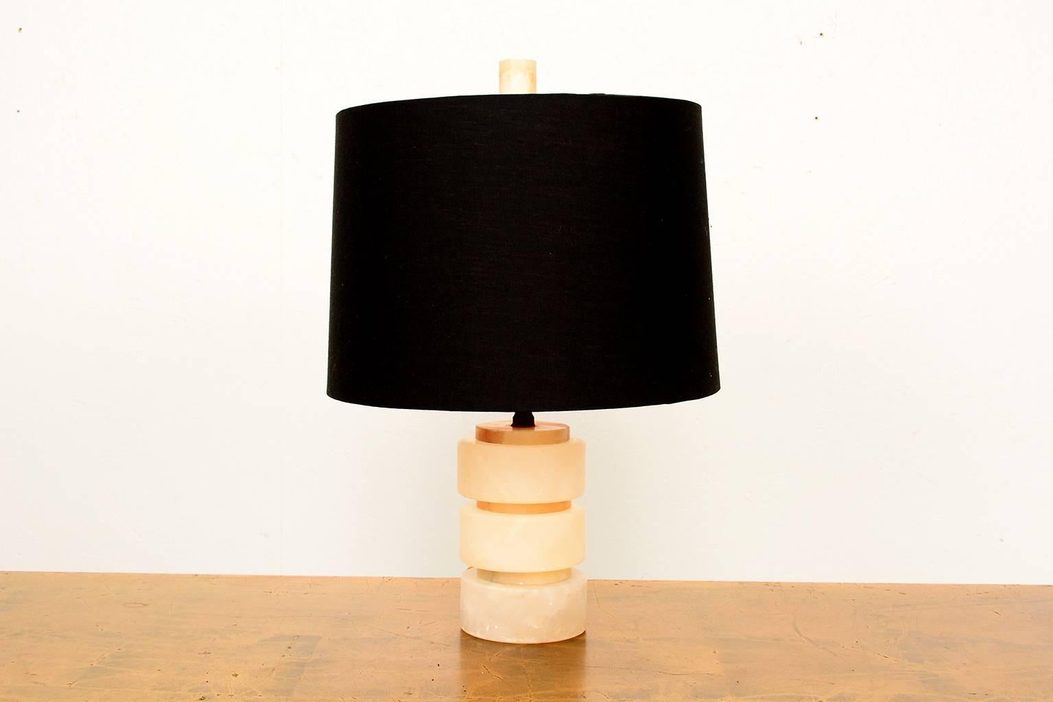 For your consideration a petite table lamp made of alabaster cylinders. 
Finial is also made of the same material. 

Black shade is not included in the sale, however we can source one for an additional fee. 

Unmarked, no information on the