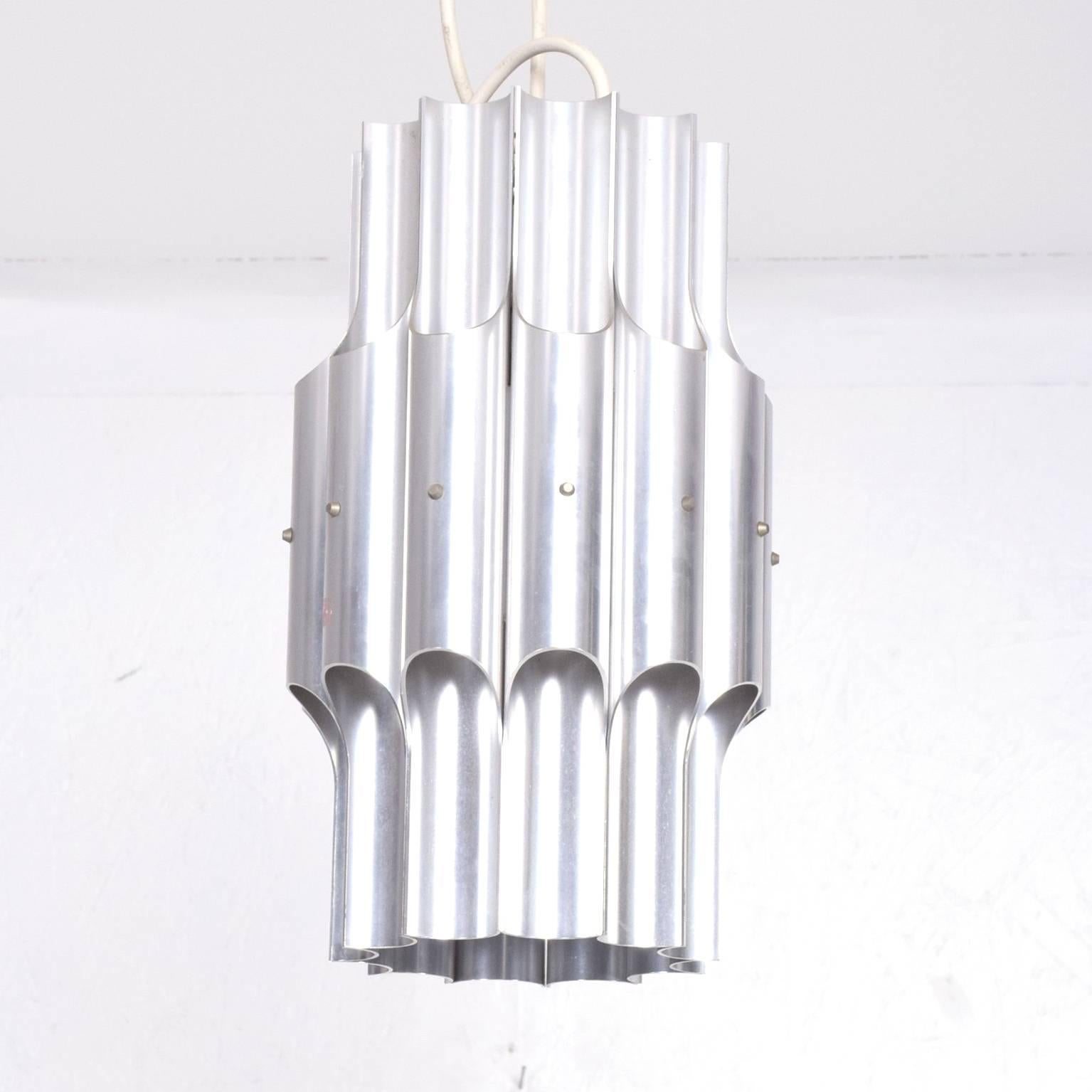 For your consideration a vintage hanging lamp constructed with aluminium tubes with sculptural cuts, allowing the light to be diffused in a very spectacular way. 

Unmarked, no information from the maker present. 

Original electrical cord, can