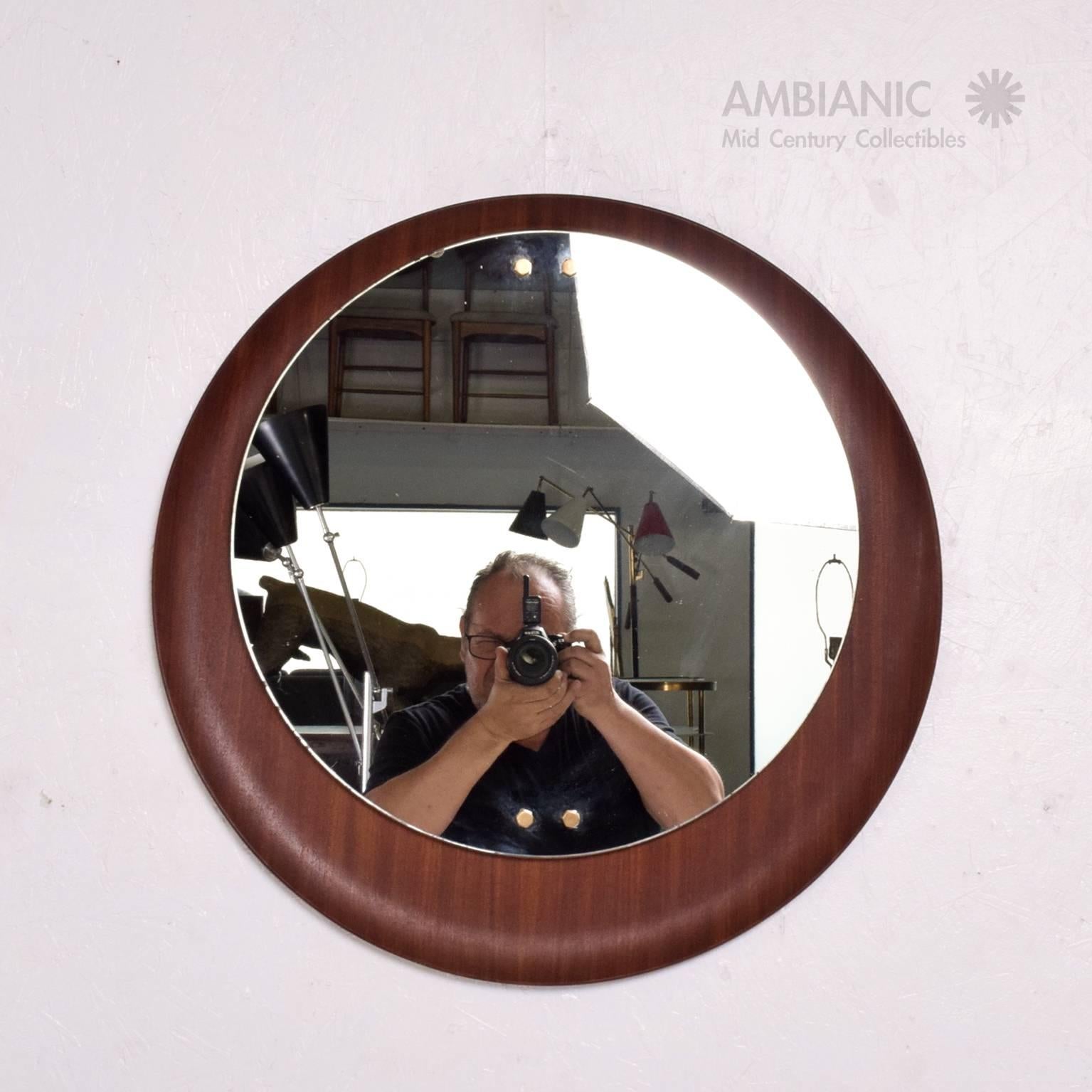 For your consideration a vintage wall mirror (Scandinavian inspired) made in Italy, circa 1960s. 

Backplate in bent plywood in sapele mahogany with original mirror secured by brass hardware.

Frame 23 3/4