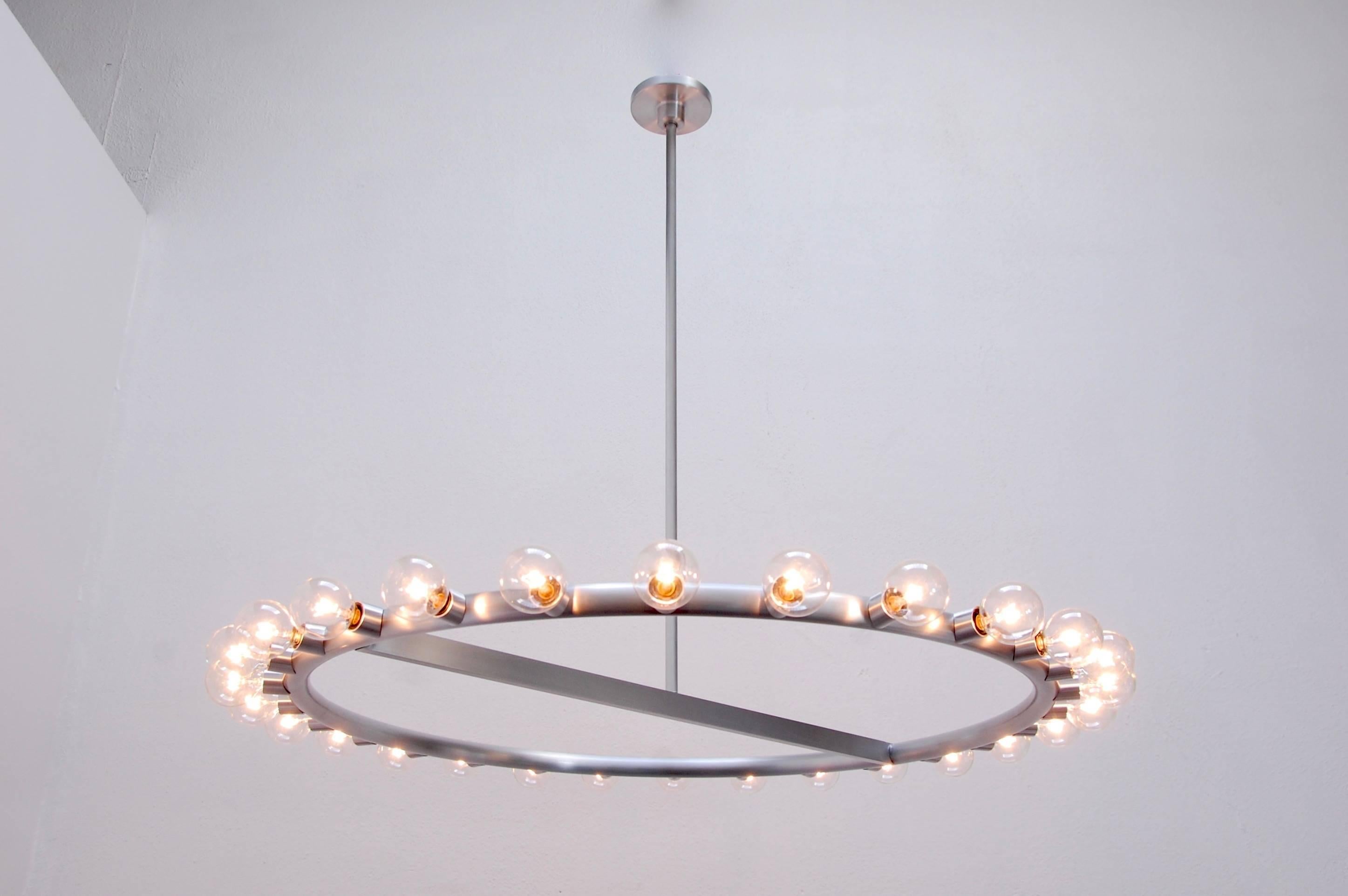 Ring of lights chandelier by Lumfardo Luminaires. 28 E12 candelabra based chandelier in satin aluminum. Part of our custom collection the Ring of Lights is made upon request. Customizable drops available.
Measures: Diameter: 30” without bulbs
35.5”