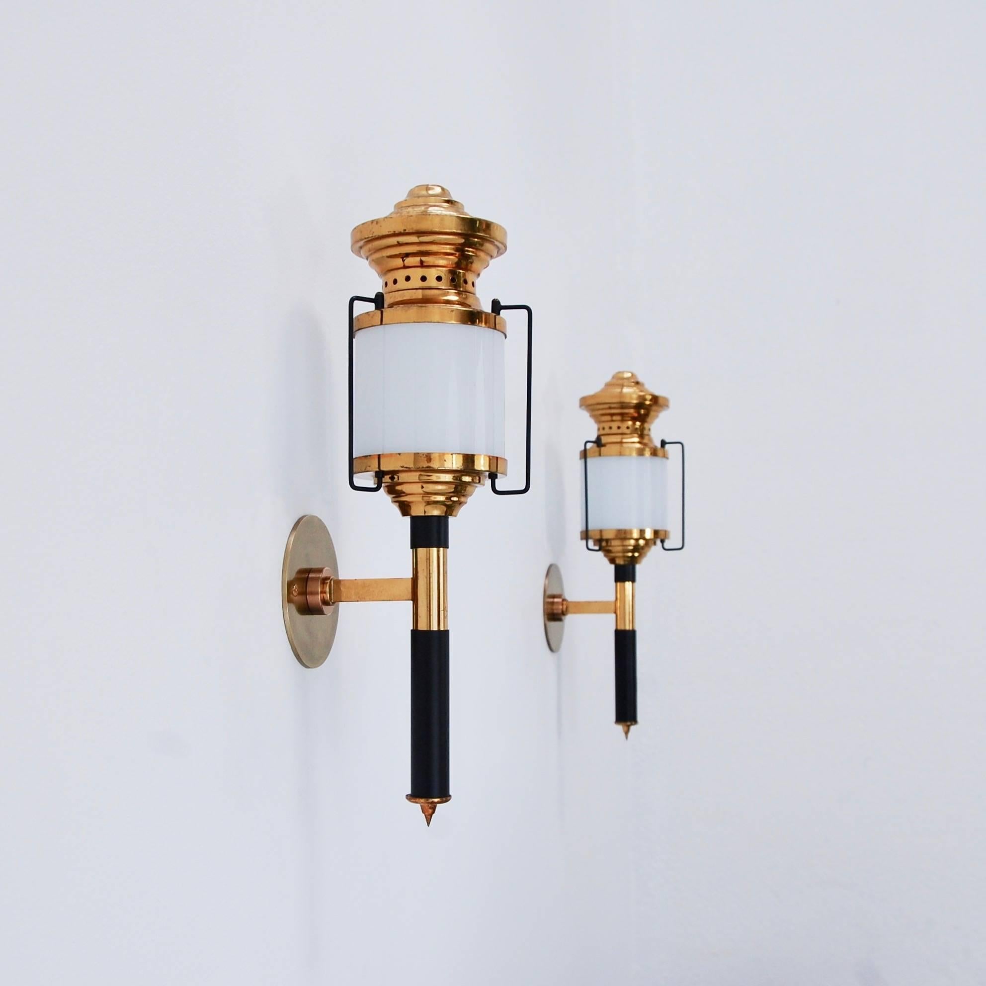Six Italian indoor/outdoor modernist lanterns from of the period 1950s Italy. Partially restored, patina lacquered brass finish with a single E26 medium based socket per glass cylinder shade. Backplate are 4