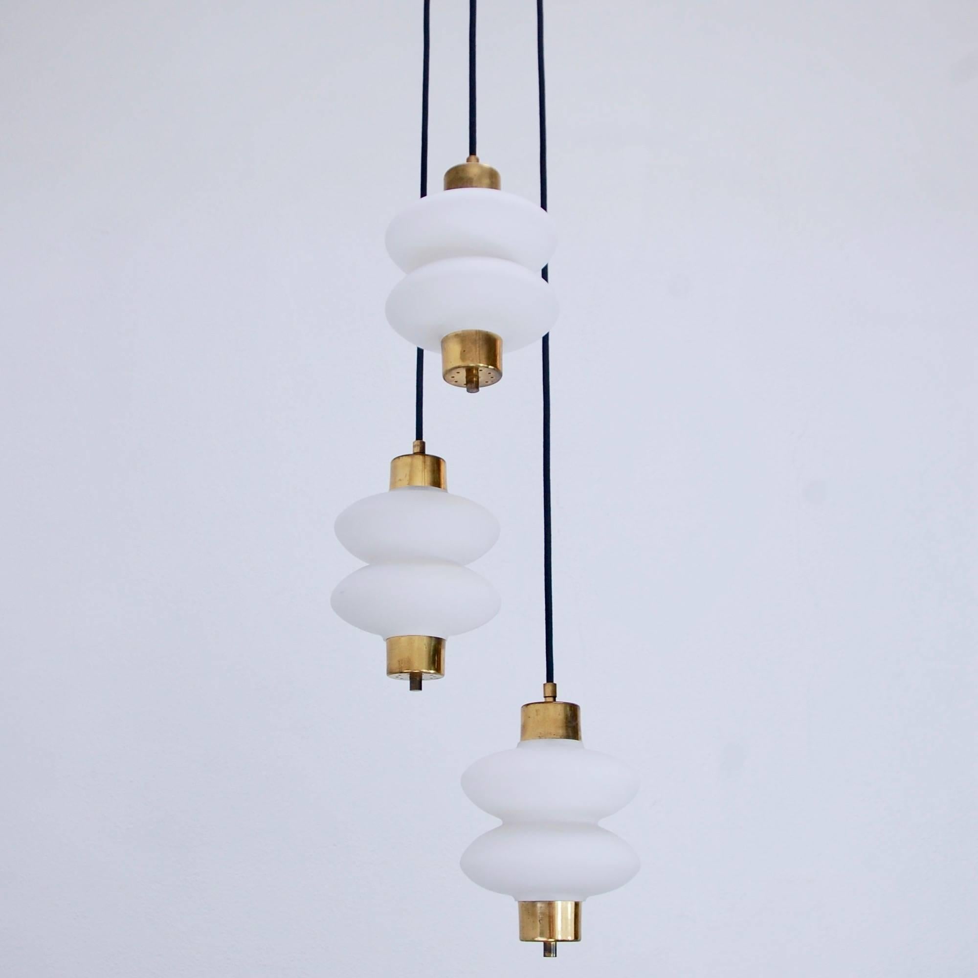 Of the period tiered three-glass shade midcentury pendant chandelier from Italy. Partially restored, original brass finish, single E26 medium based socket per shade, wired for the US. Overall drop adjustable upon request.
Measures: 11” H x 7” W