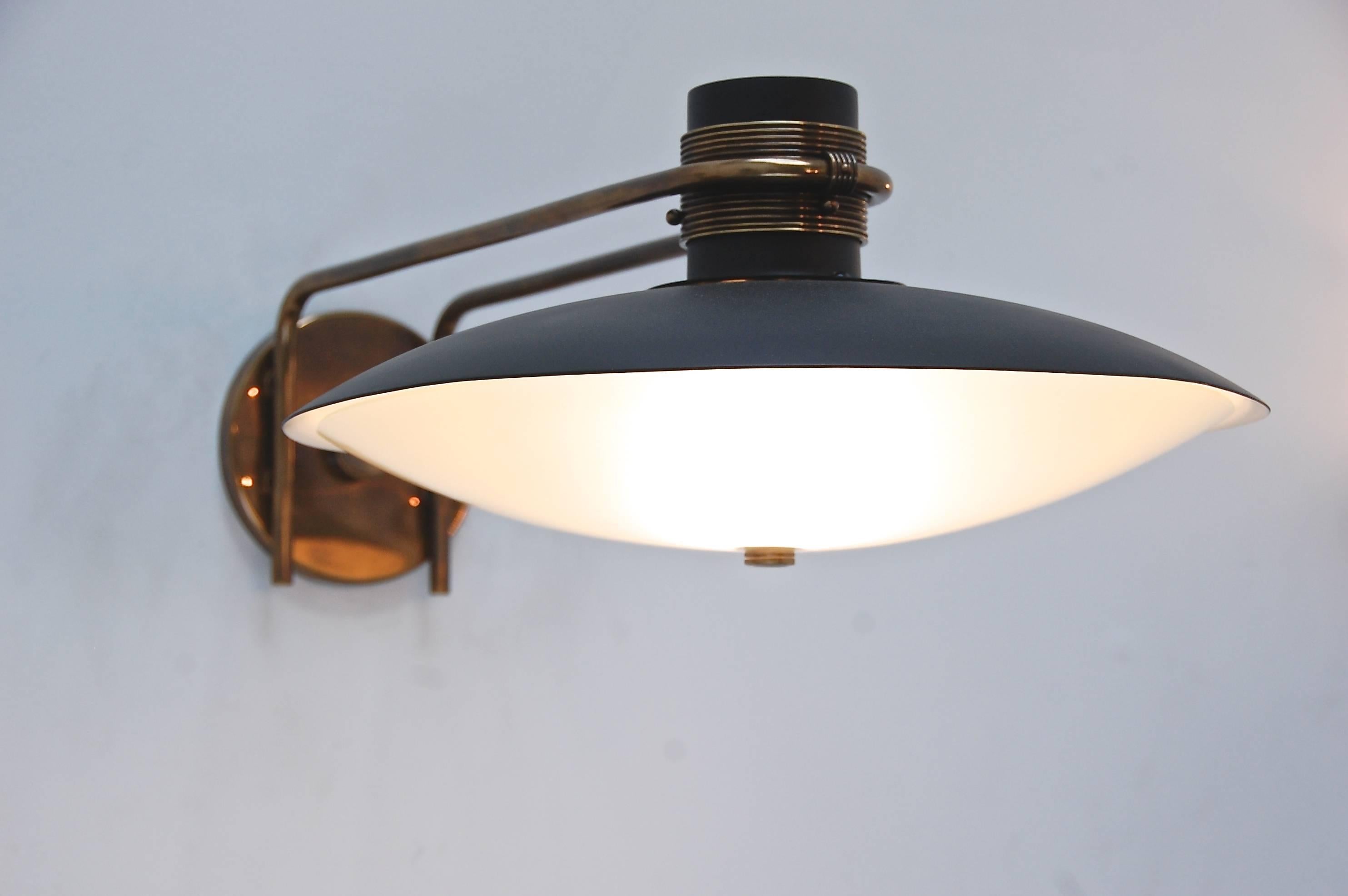 Unique Italian studio wall lamp made from brass, painted aluminum and blown glass. Beautiful hardware frames the dome shaped fixture. Two-light sockets, one medium based and one candelabra based to allow light to exit from the top and bottom of the