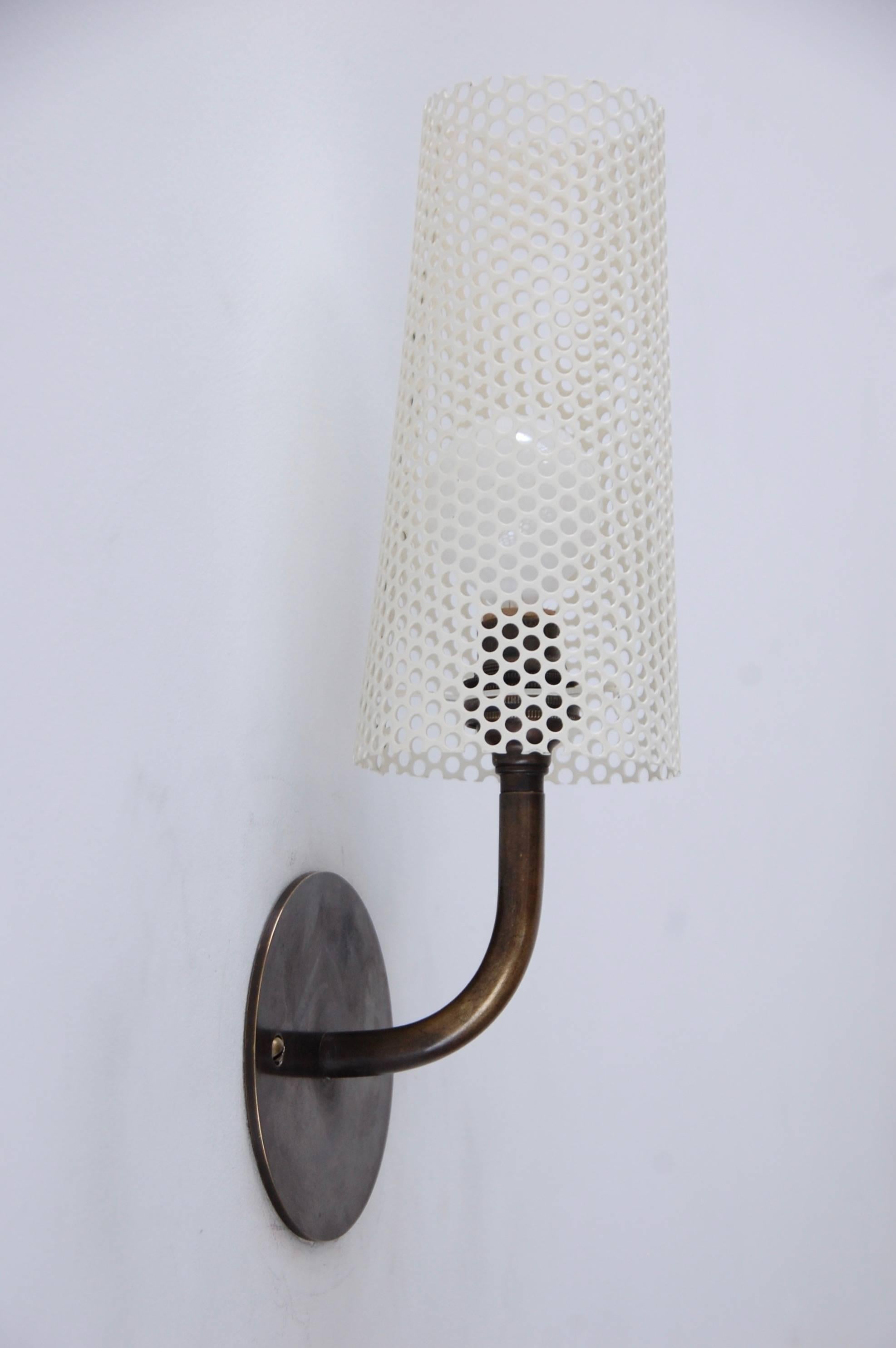 Sharp looking perforated sconces in the style of French designer Disderot. In perforated painted steel and brass. Can be wired for anywhere in the world. Light bulb included with order. 
Measurements:
4
