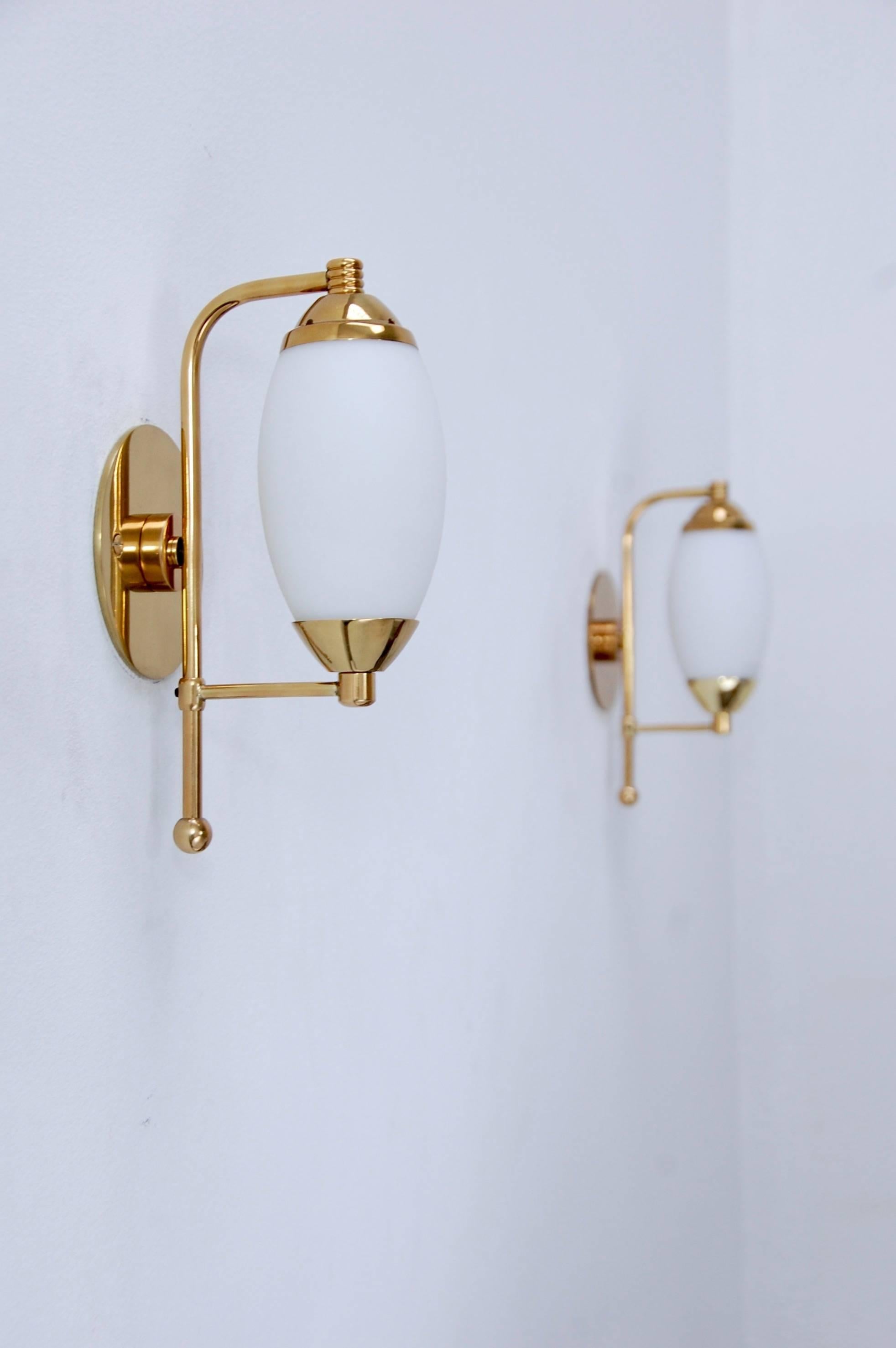 A pair of fully restored Mid-Century Italian brass and blown glass library sconces from the 1950s. Single candelabra based sockets per sconce. Patinated lacquered brass finish.