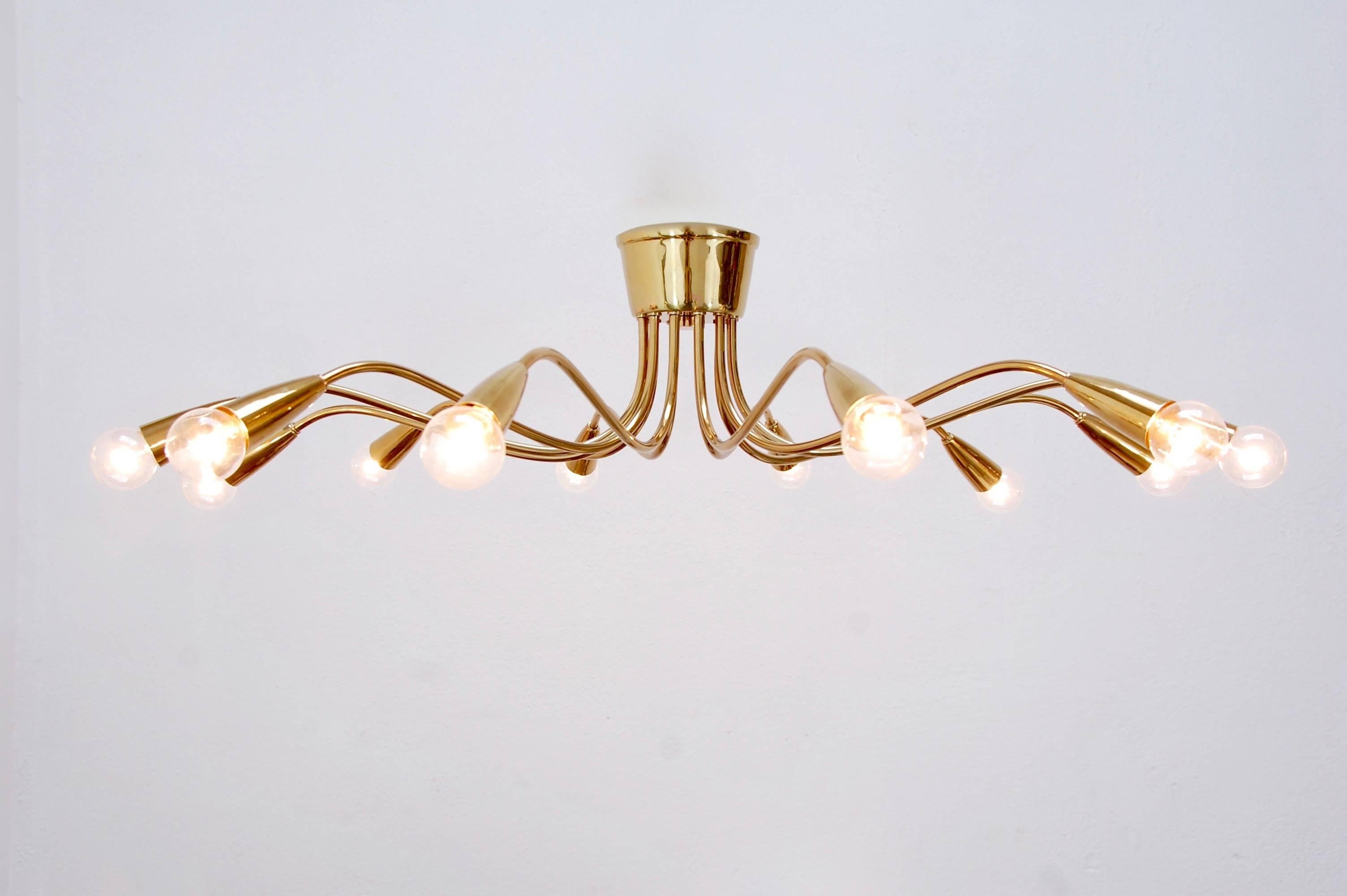 Stunning twelve-arm Italian brass flush mount chandelier from 1950s, Italy. Restored and rewired for use in the US. Patina lacquered brass finish. Candelabra based sockets.