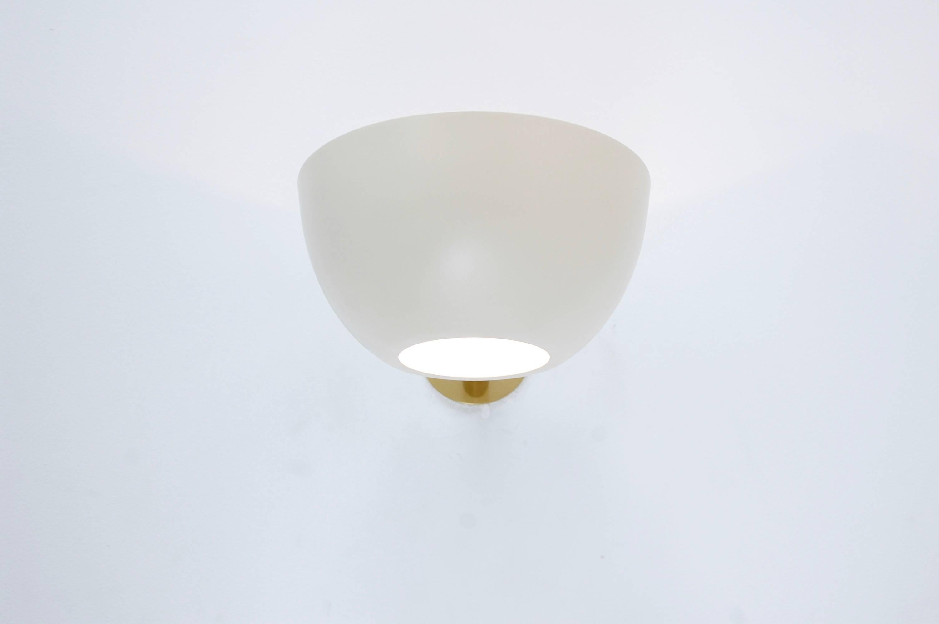 Inspired by 1950s Italian design, this contemporary sconce is a companion piece to our large LUcrown chandelier. Single medium based socket. Painted aluminum shade and lightly aged brass hardware with glass diffuser. Priced individually, multiples