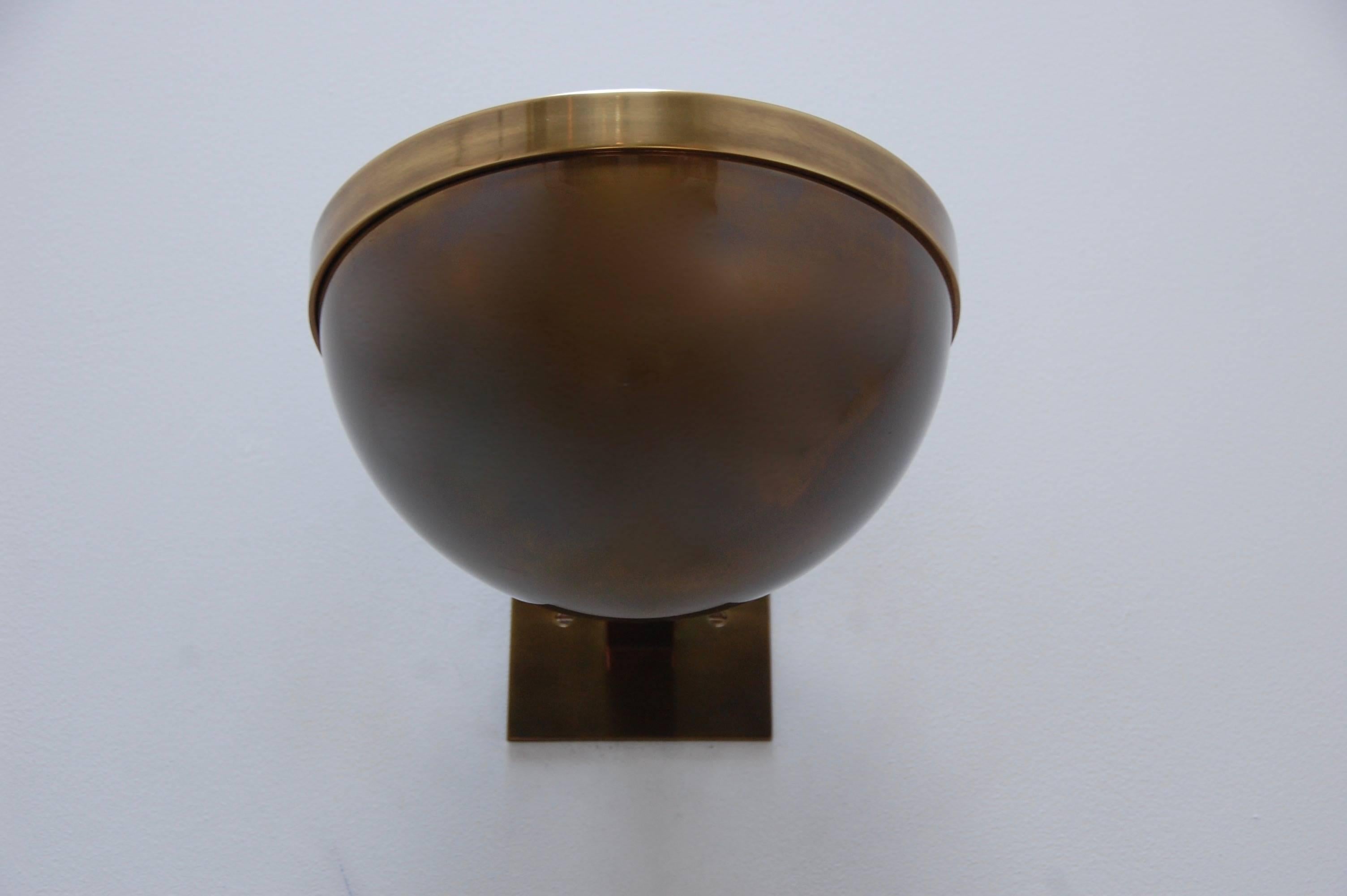 Fabulous and sleek modern Juni bowl sconce in solid aged brass. Manufactured by Lumfardo Luminaires, based on a French design. Single medium based E-26 socket. Multiples available to order. Lightbulb and mounting hardware supplied with order. 