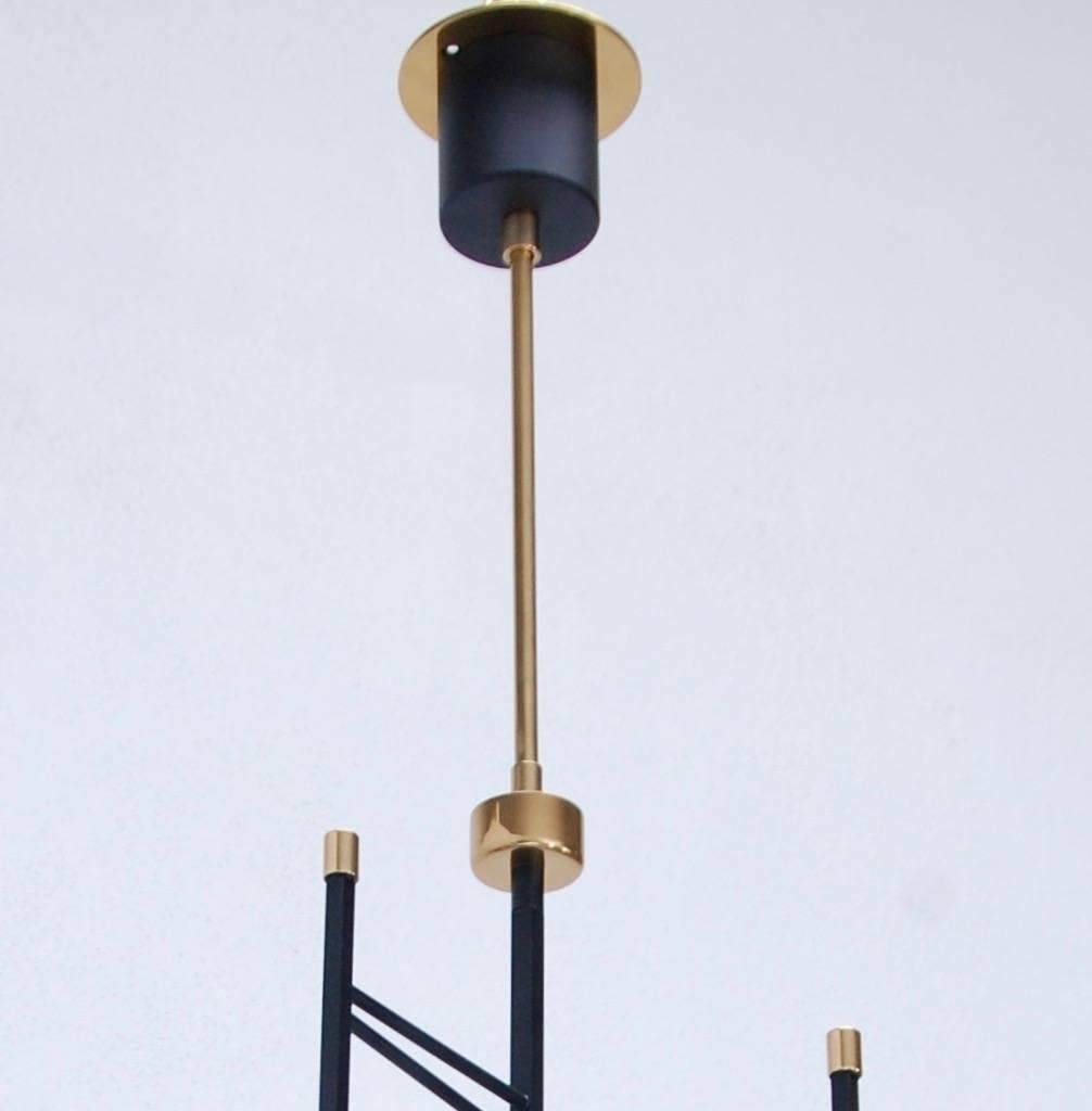 Elegant geometric brass and glass pendant from Mid-Century Italy in the manner of Stilnovo. Fully restored. Single candelabra based sockets per glass shade. Four glass shades.
Measures: Diameter 13.5”
Fixture height 24.75”
OAD: 38.25”.
 