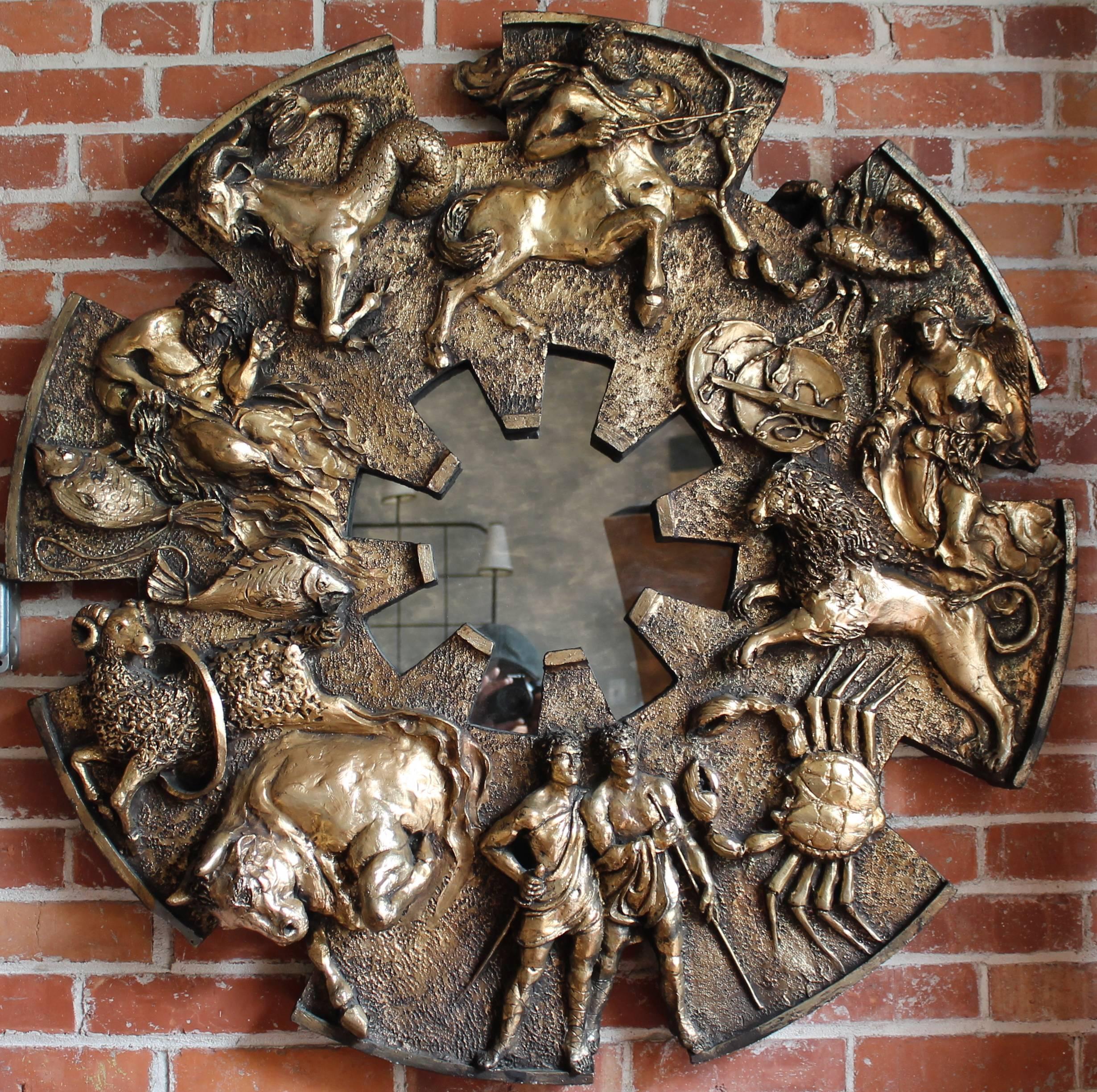 Outrageous 1970s Brutalist style zodiac relief figures mirror.
Framed by a bold zodiac wheel with the twelve astrological signs.
Cast resin with bronze finish. 
Made in the USA By Finesse Originals.