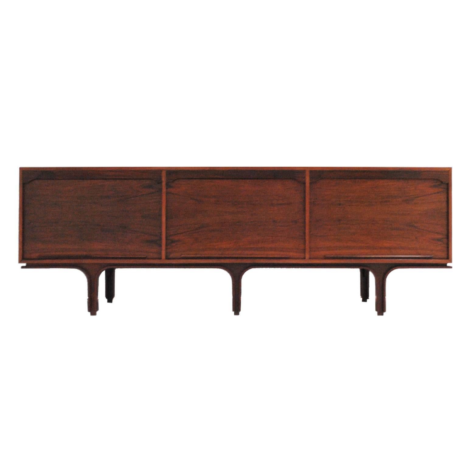Sideboard designed by Gianfranco Frattini for Bernini. Made in solid wood with rosewood finish. It is composed of three doors with front in blind and drawers on the inside.