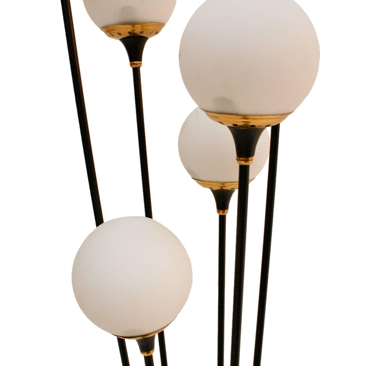 Floor lamp designed by Stilnovo, consisting in six points of light with structure made in black lacquered iron with brass finishes and marble base.