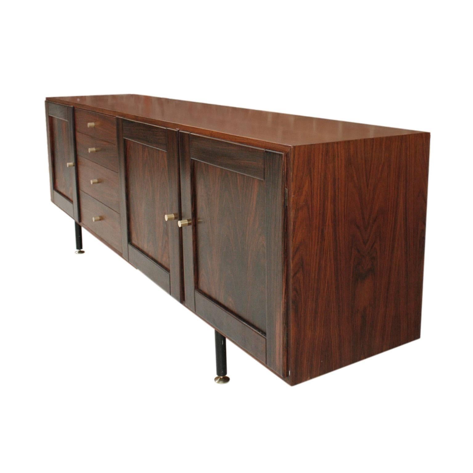 Sideboard made of solid wood covered with rosewood, structured in four bodies of doors and drawers. Metal legs with brass terminations.