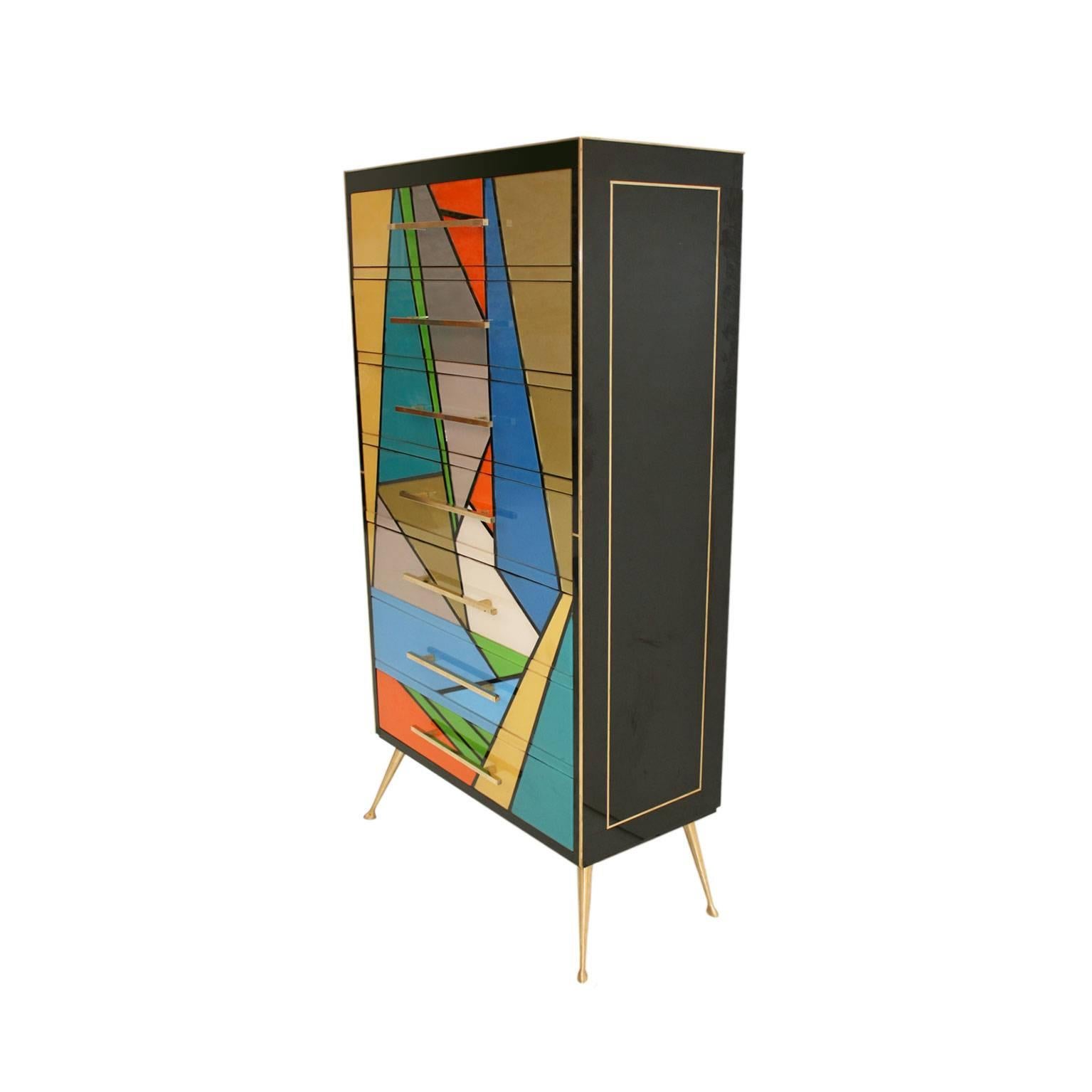 Italian commode with seven drawers, made of solid wood structure from the sixties. Currently reinterpreted and covered by hand in Murano glass in different colors with handles and details in brass. Legs made in bronze.