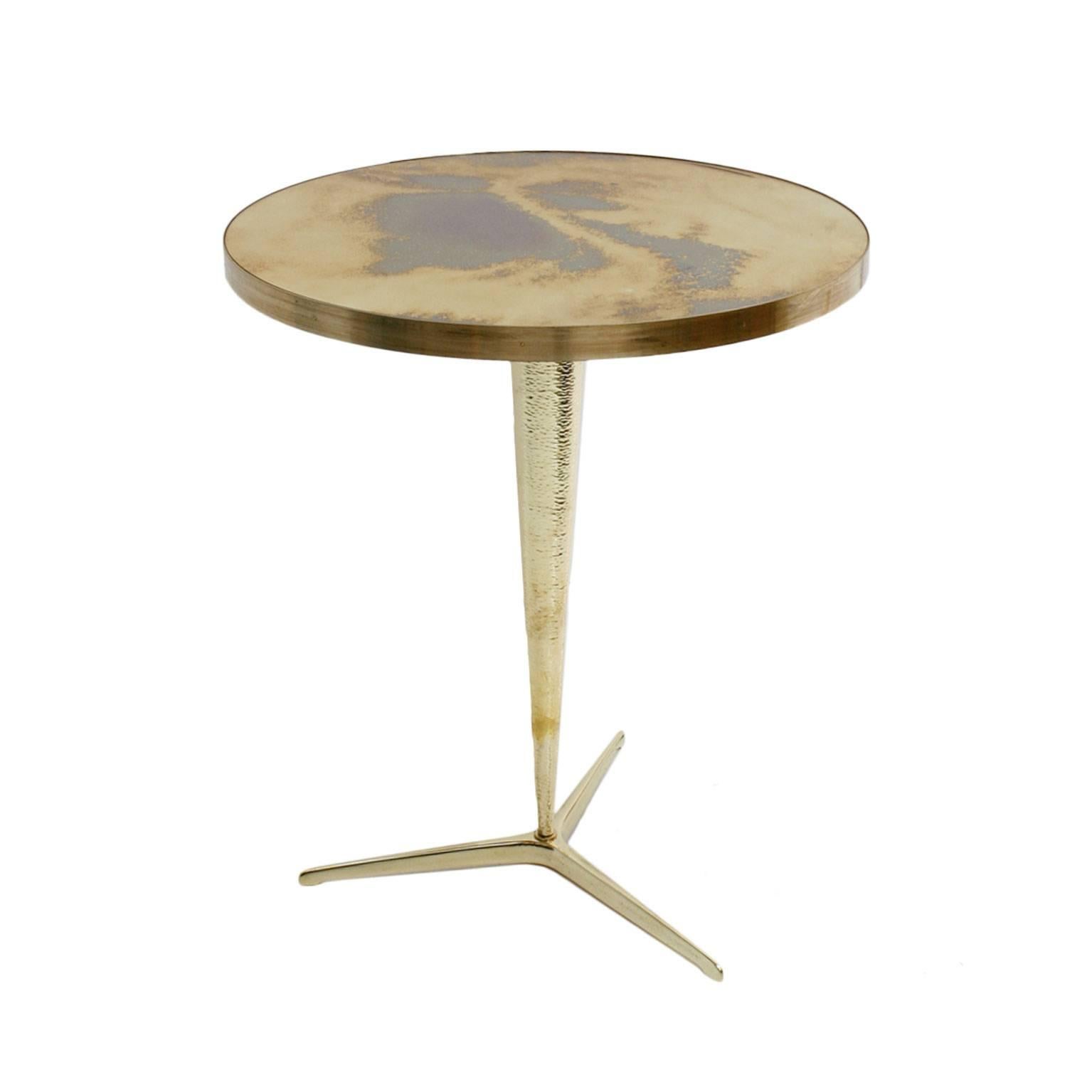 Pair of pedestal tables with brass structure, handmade hammered base, bronze feet and aged mirror glass envelope, Italy.